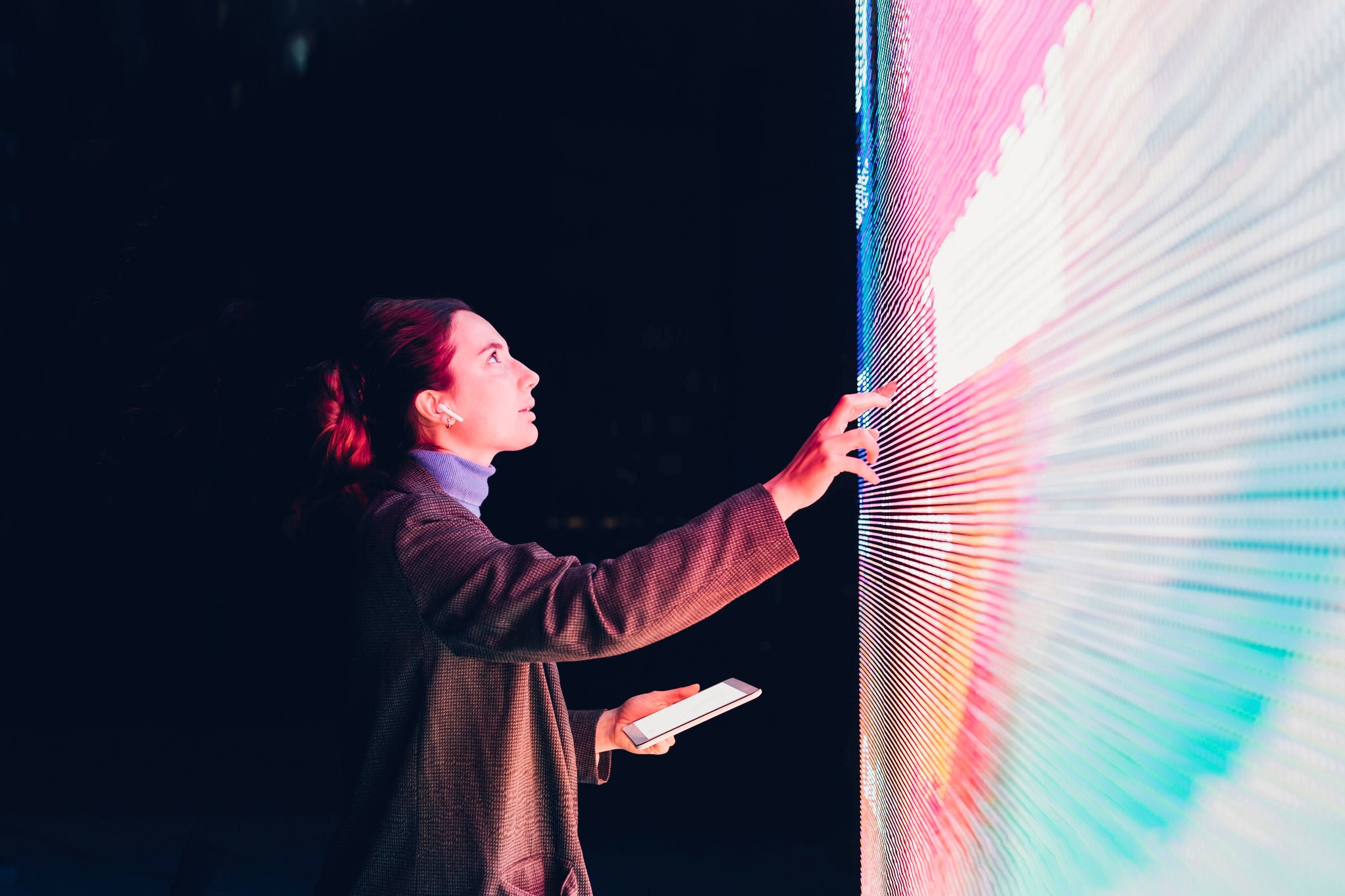 Businesswoman using touch screen interactive information booth at night