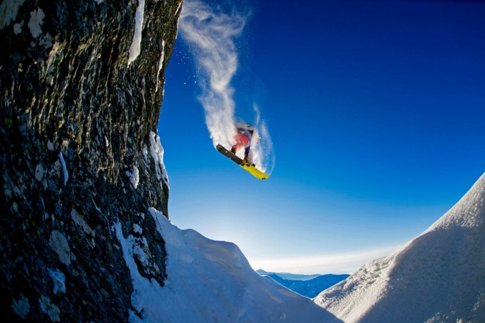 Snowboarder jumping over rocks Austria