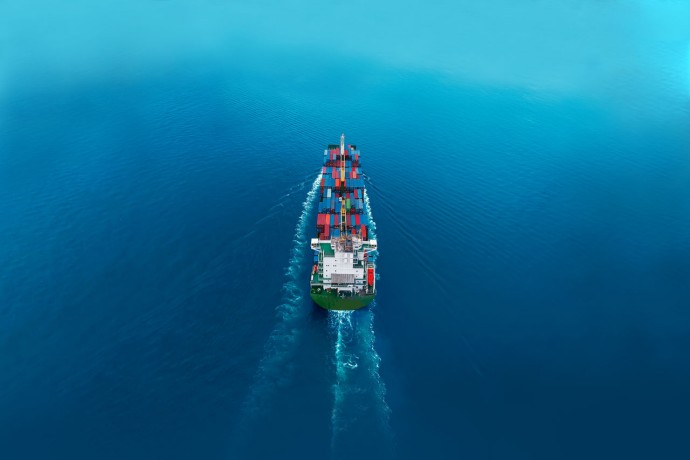 Aerial view of cargo ships in containers sailing in the sea background