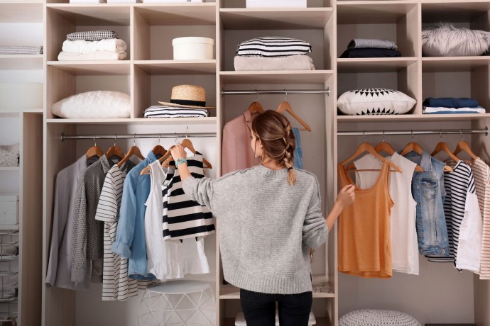 Woman choosing outfit from large wardrobe