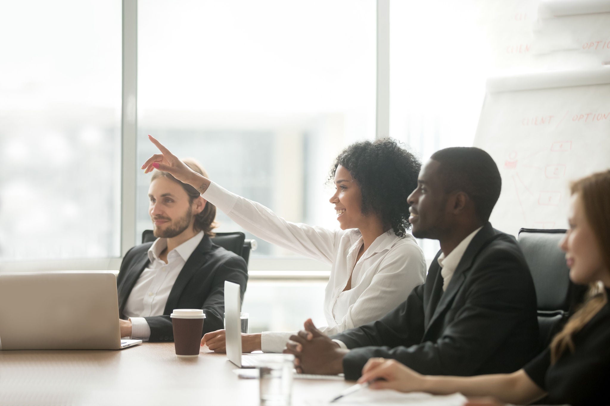 Business woman raising hand to ask question at team training