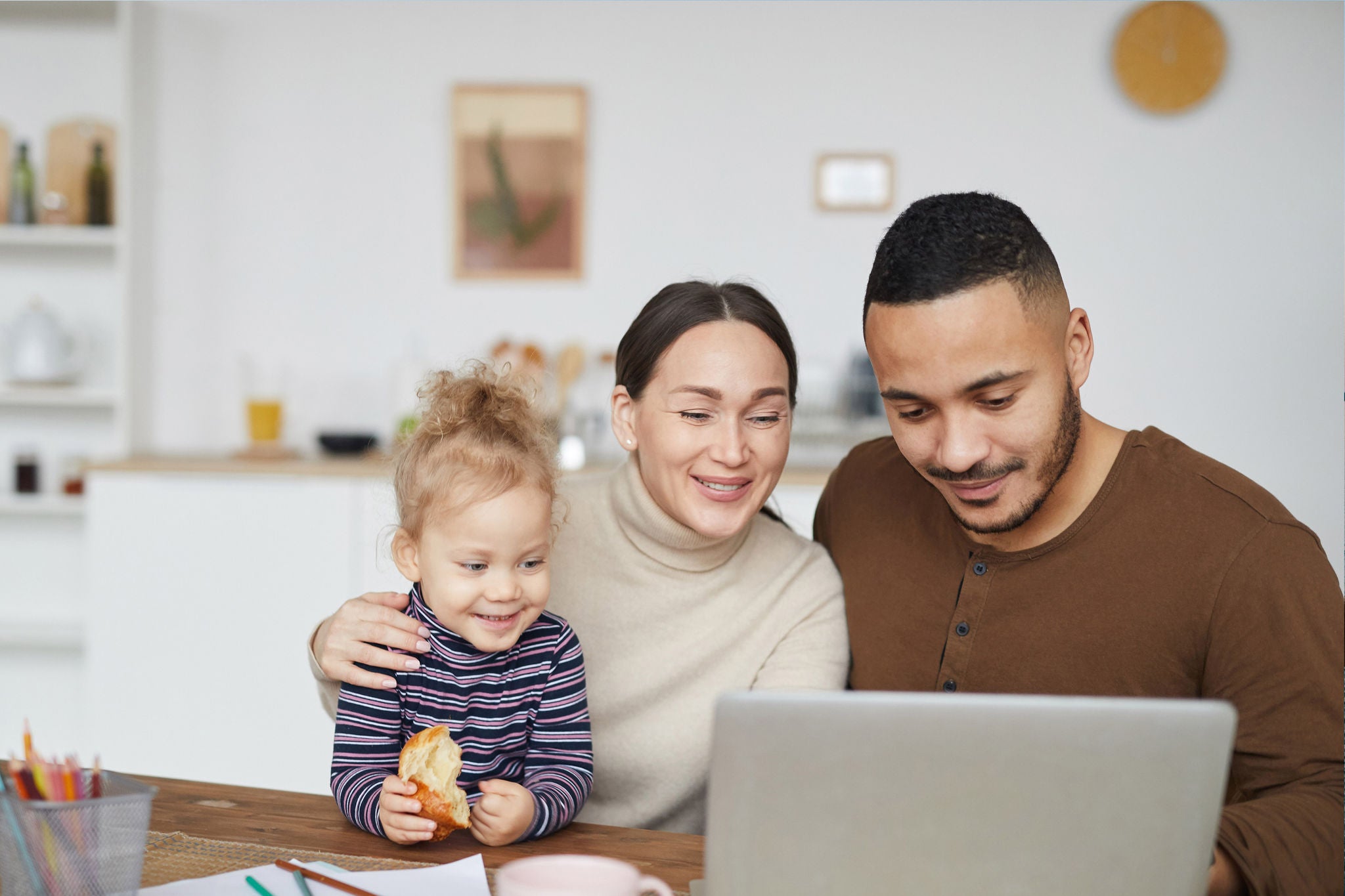 Portrait of smiling mixed race family using laptop together while shopping online, copy space