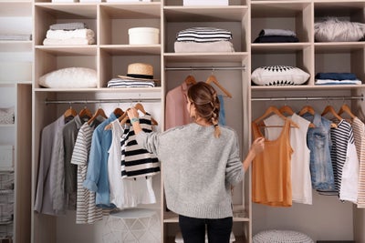 Woman choosing outfit from large wardrobe