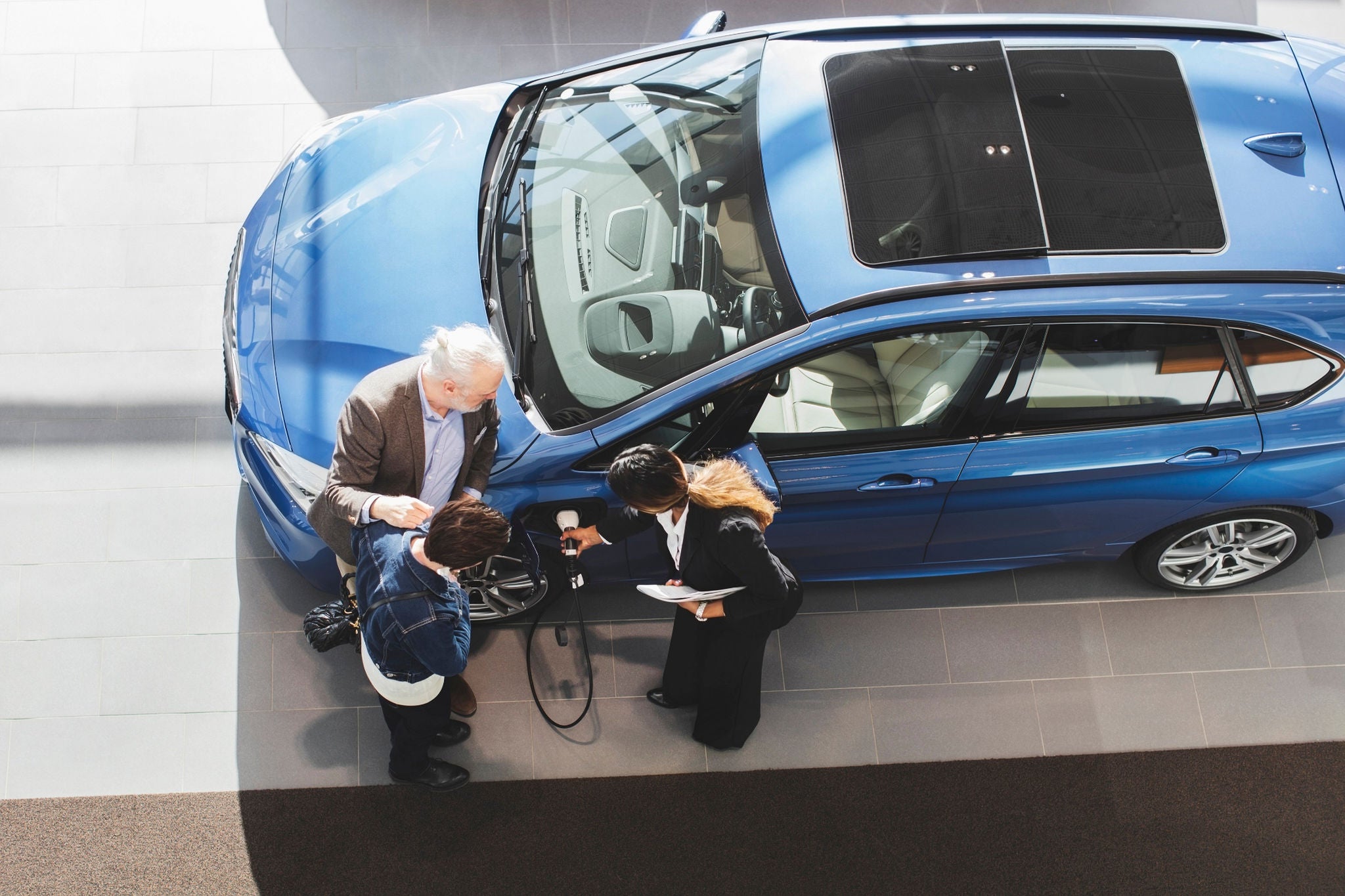 People viewing an electric vehicle being charged