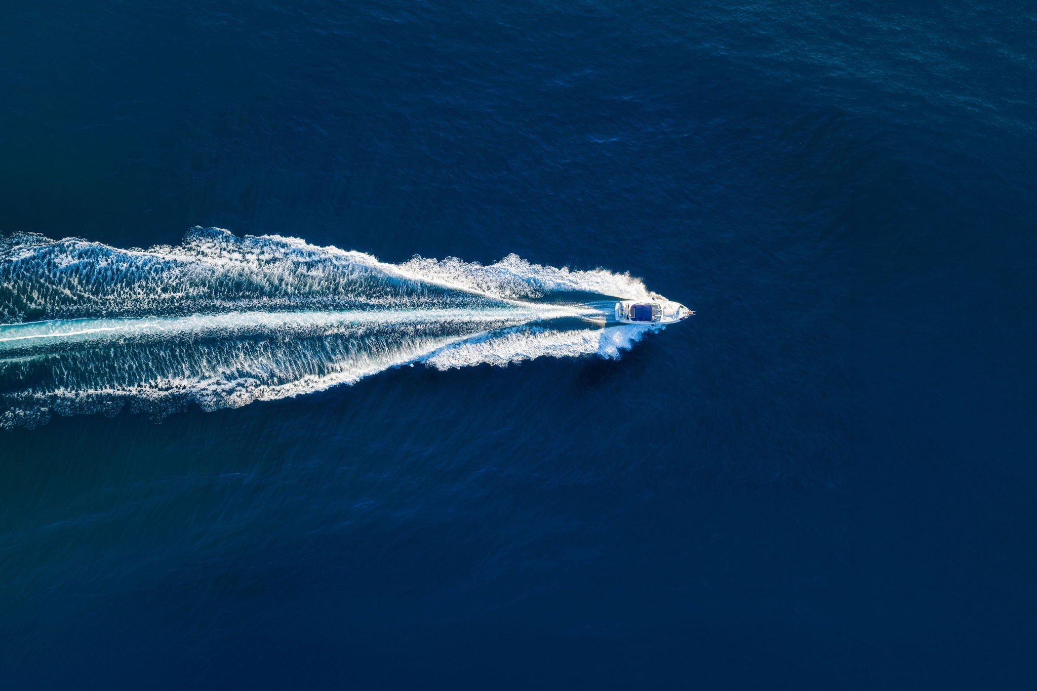 Vacation and leisure. Aerial view on fast boat on blue Mediterranean sea at sunny day. Fast ship on the sea surface. Seascape from the drone. Seascape from air. TSeascape with motorboat.