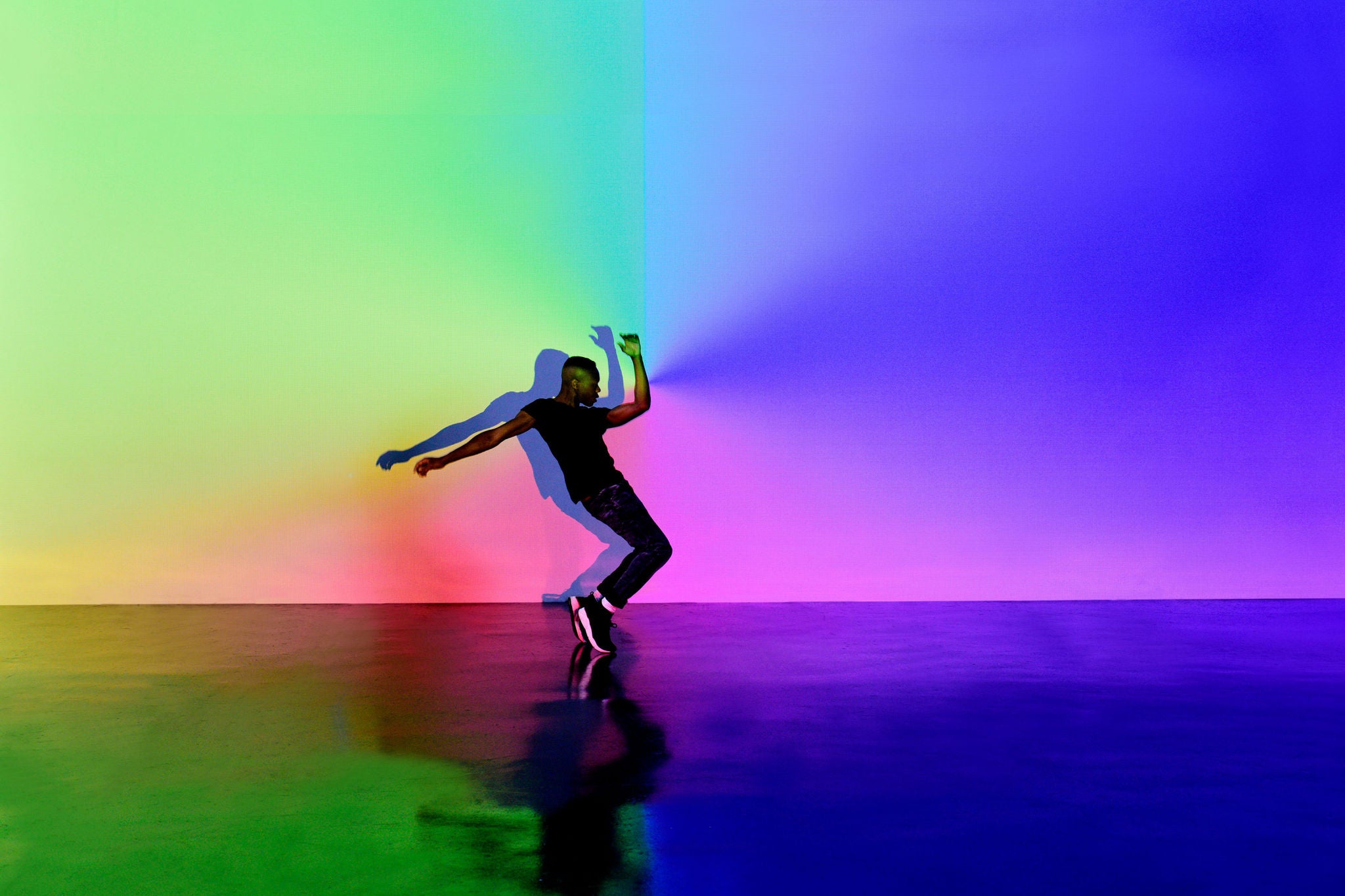 Hombre baila sobre un fondo colorido