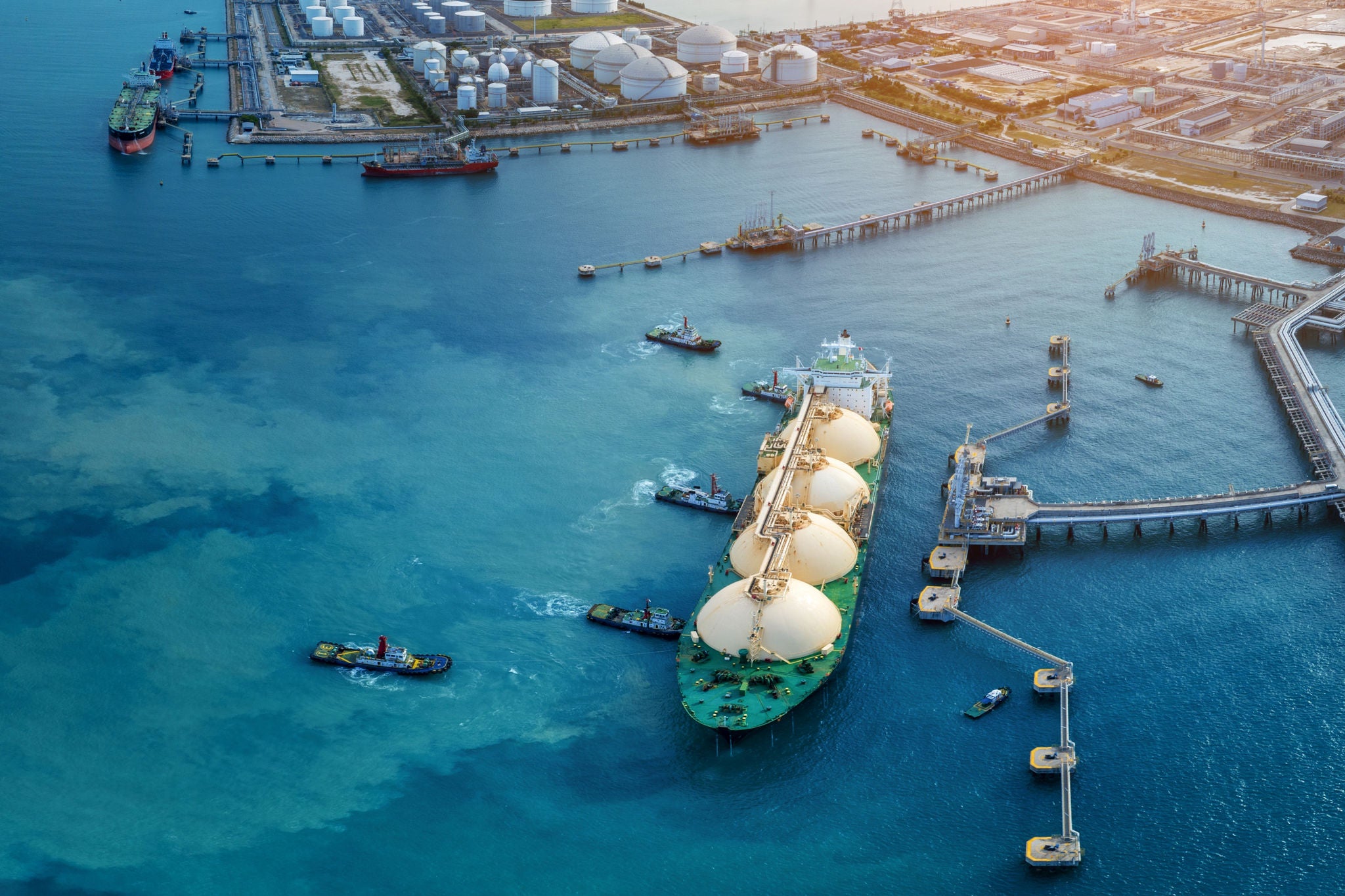 Methanier accostant dans un port industriel avec reservoirs