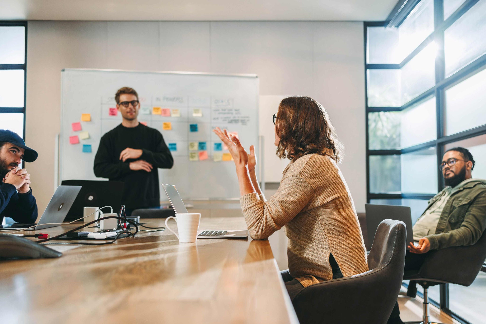 Teammeeting in einem Büro mit Whiteboard und Laptops