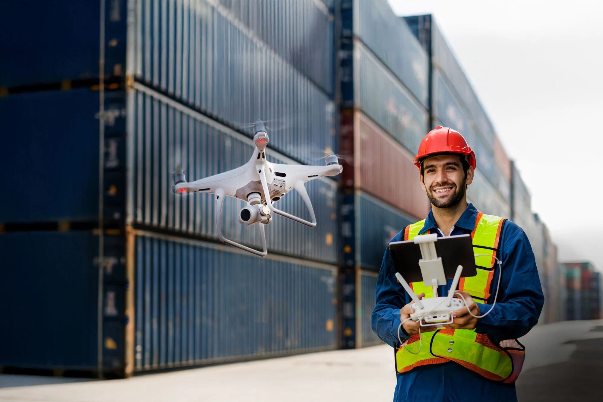 Foreman or worker use remote controller piloting drone at containers port for checking container. Foreman use remote control Drone with camera flying on container cargo ship at shipping port