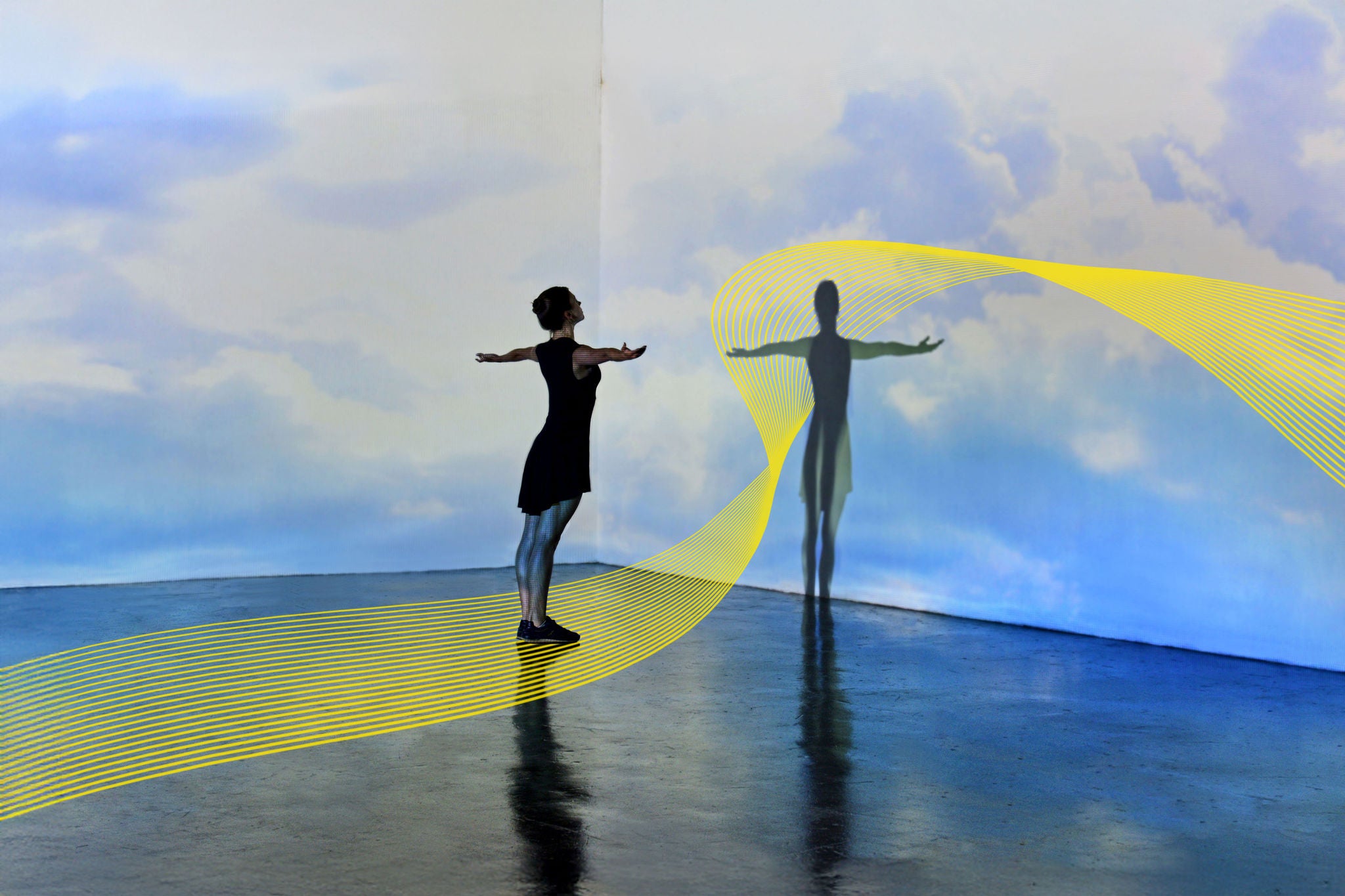 Girl looking at a large scale sky image being projected onto the walls of a gallery space