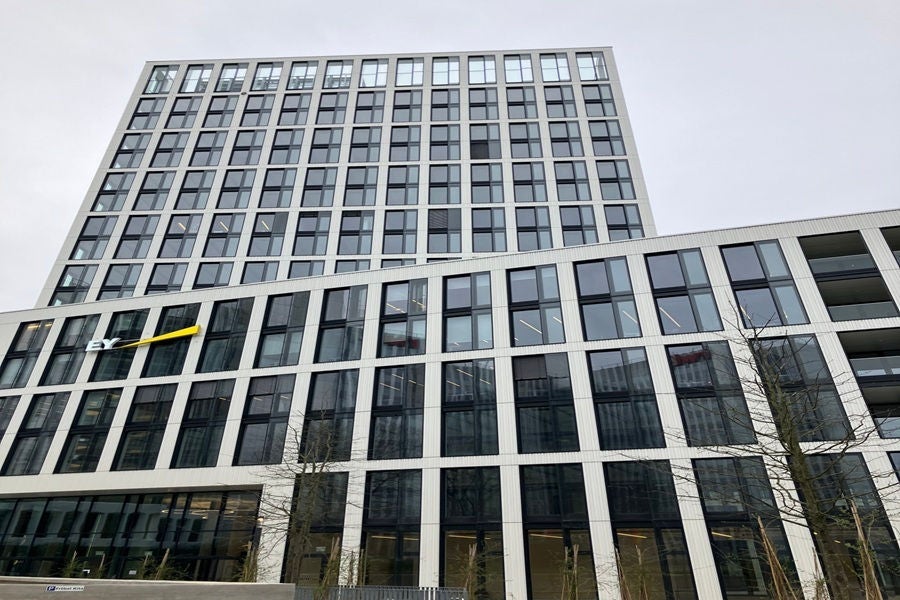 Modernes Bürohochhaus von EY mit klaren Linien, Glasfassade und urbanem Design.