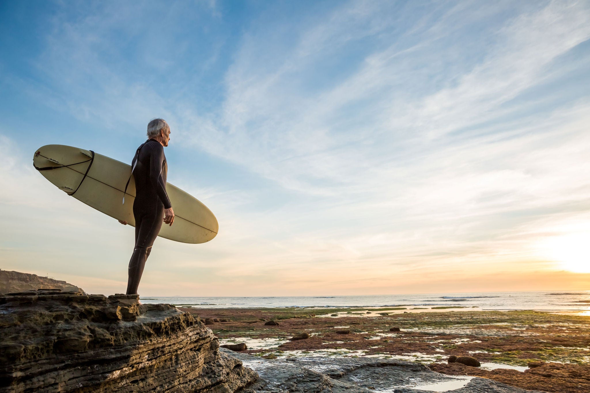 Homme âgé tenant une planche de surf