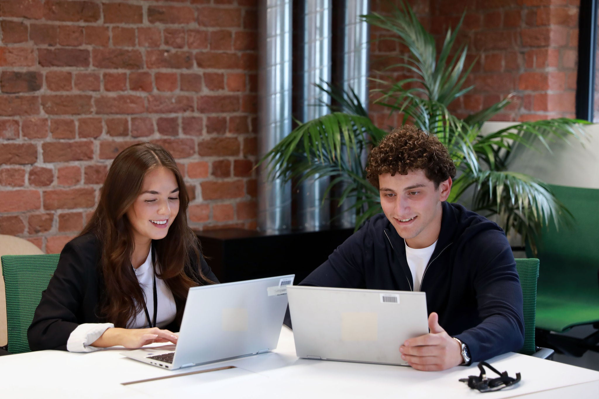 Two colleagues working on their laptops