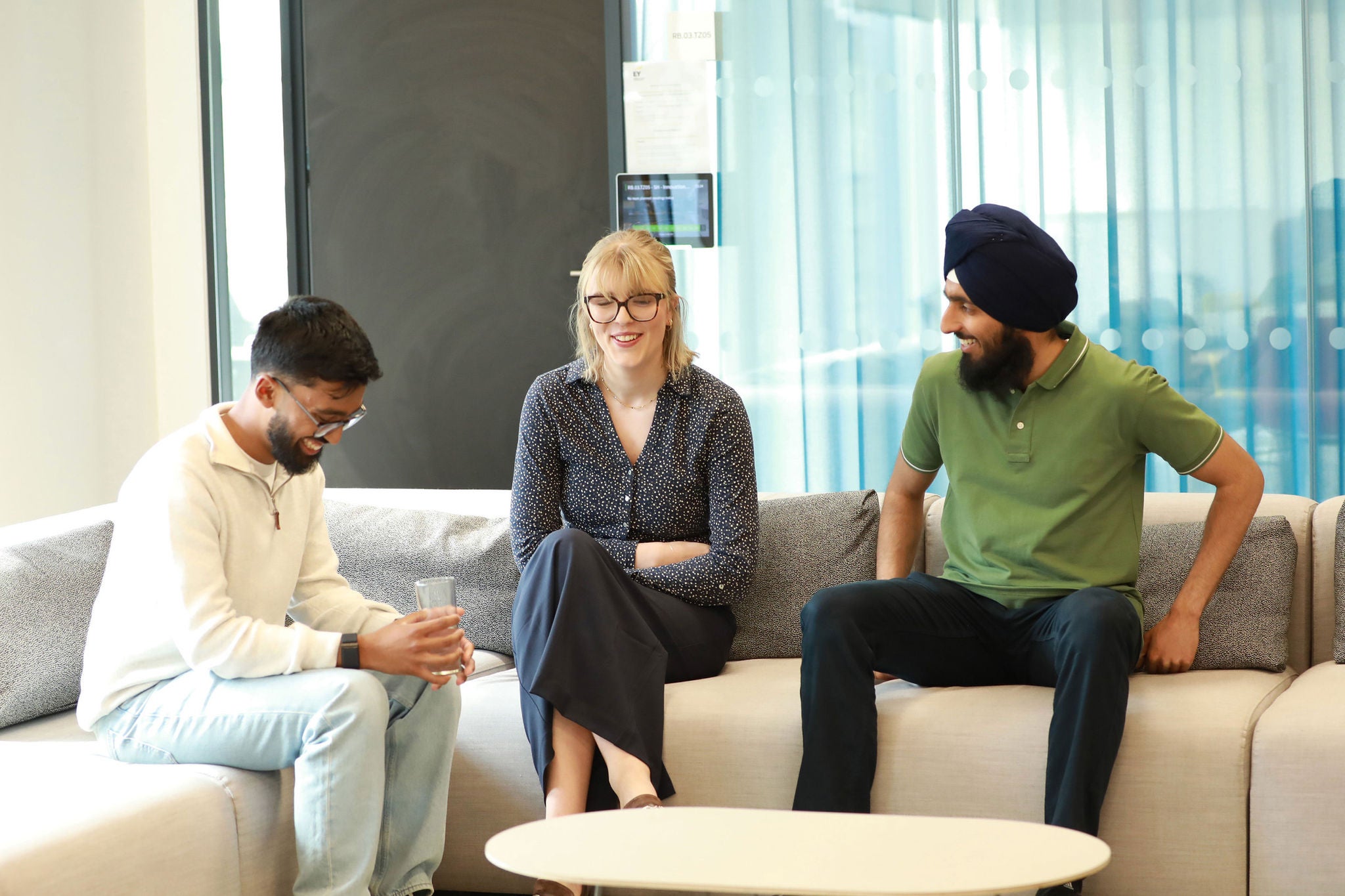 Three colleagues seated together in a collaborative space