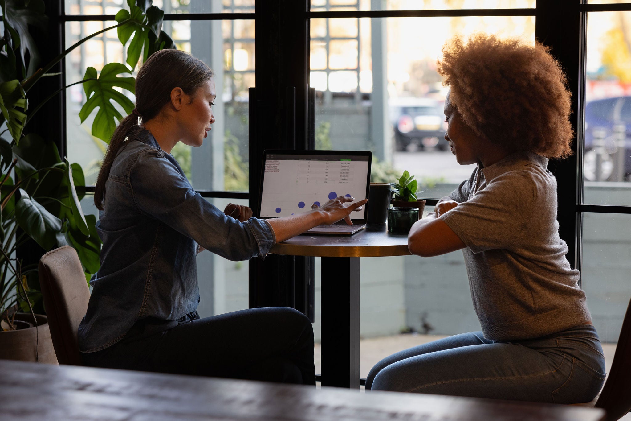 Two coworkers discussing data together in a casual meeting