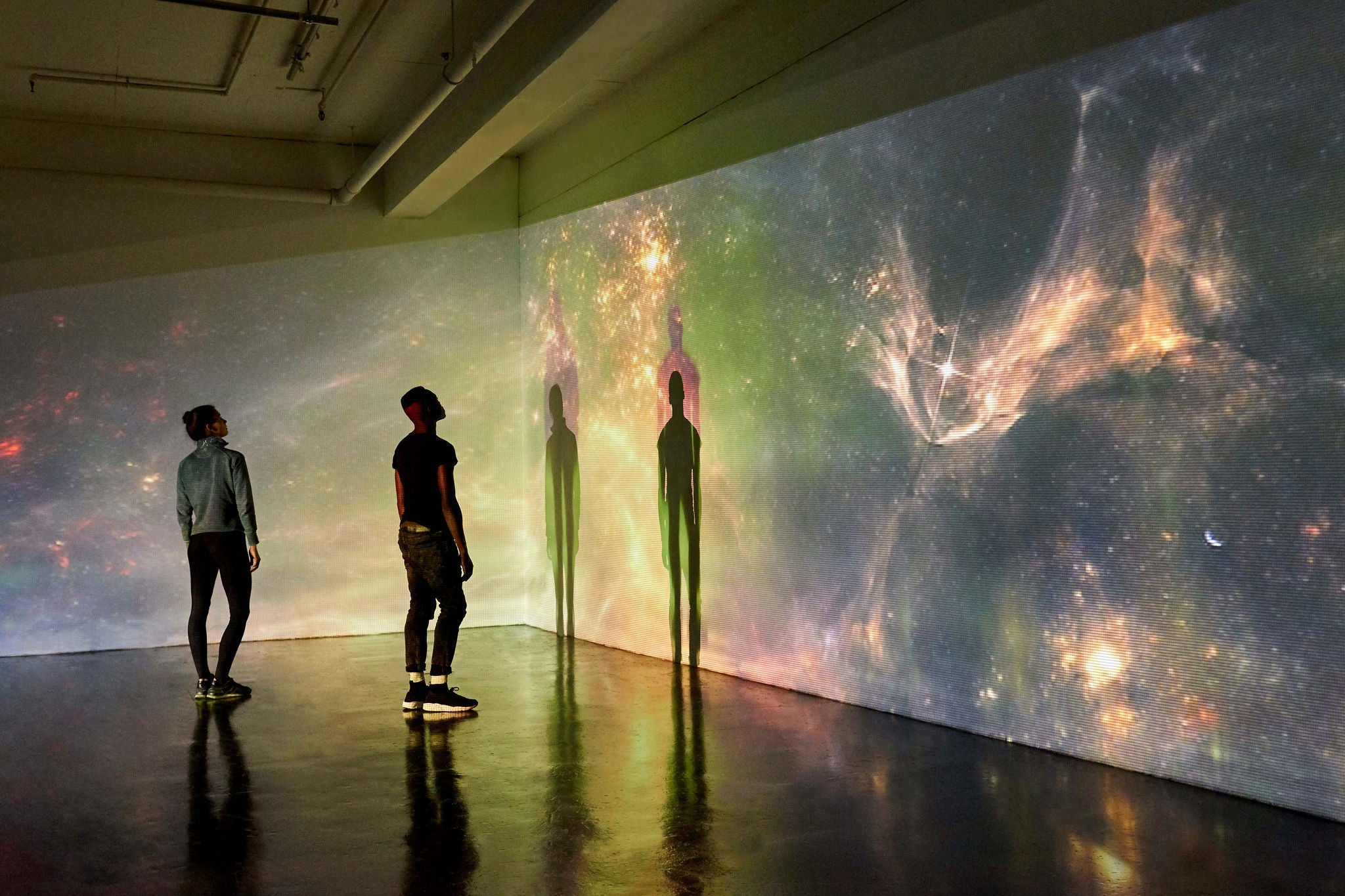 Couple Looking at Large Scale Projected Image of Space