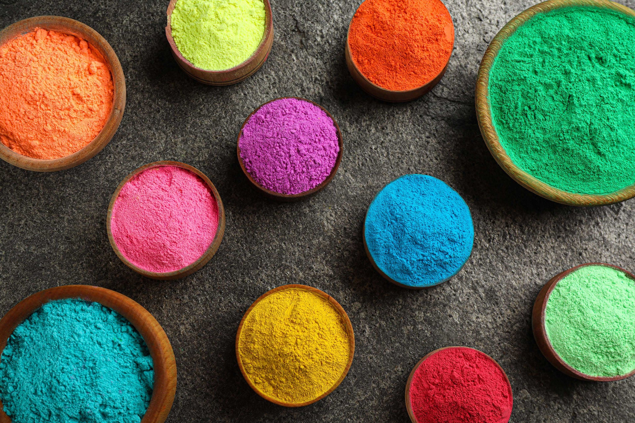 Colorful powder dyes on grey background, flat lay. Holi festival