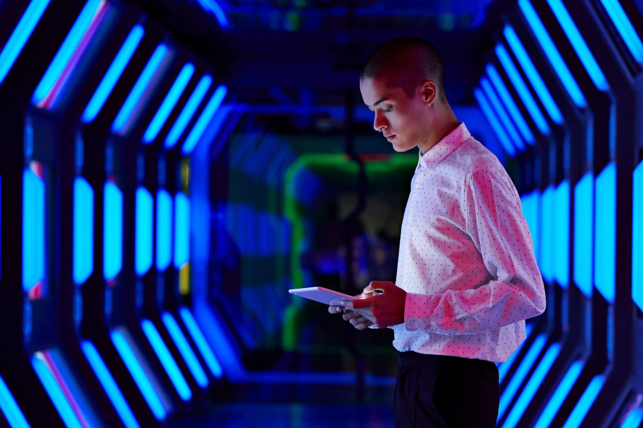 Man using a tablet in a futuristic looking tunnel
