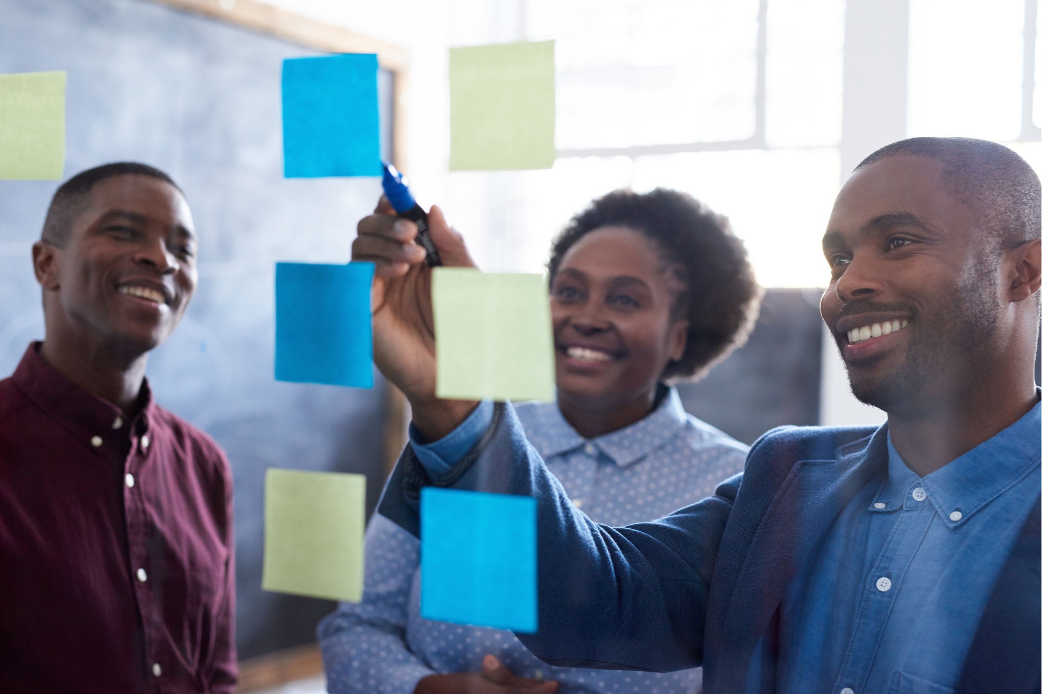 Positive EY work colleagues brainstorming together in an office