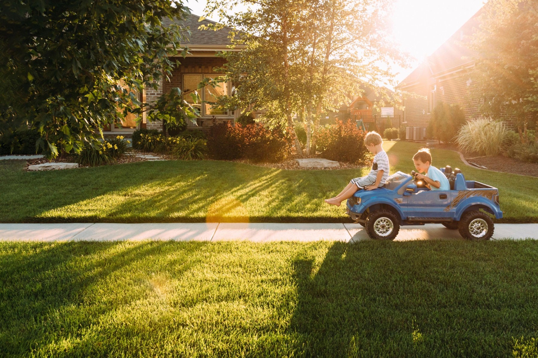 ey siblings playing toy car footpath walkway