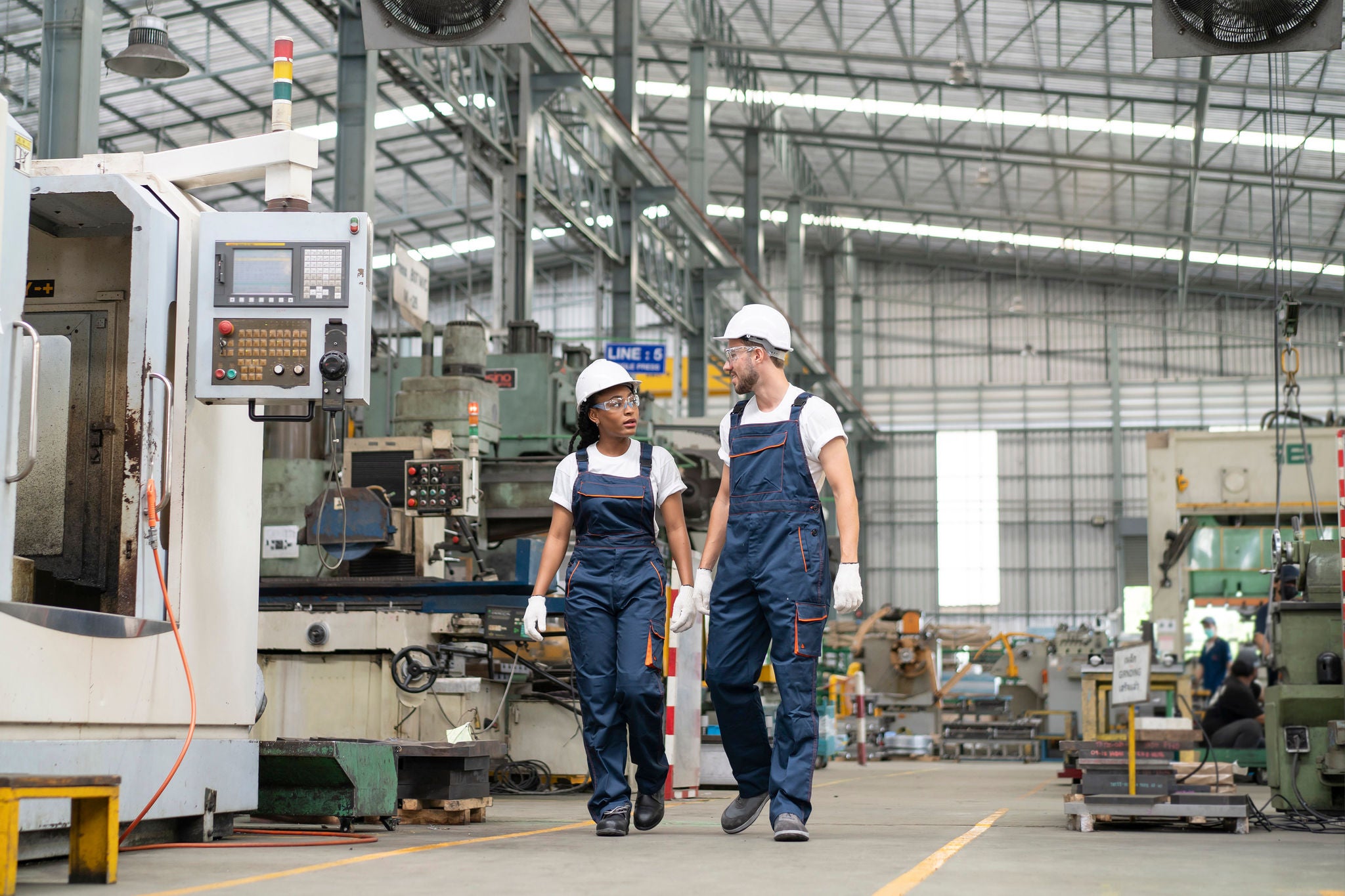 Two Engineers Walking Through An Automated Factory And Talking