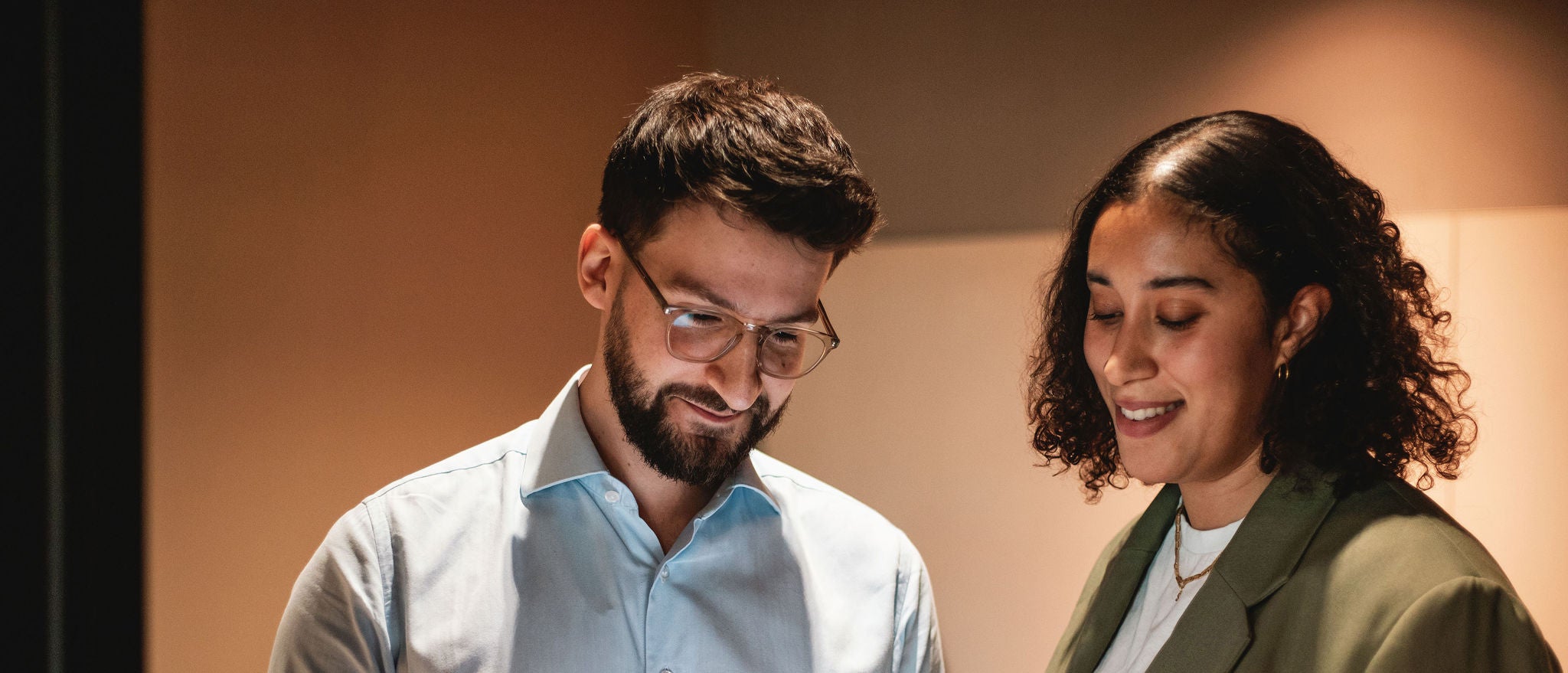 Professionals reviewing information together on tablet during office discussion