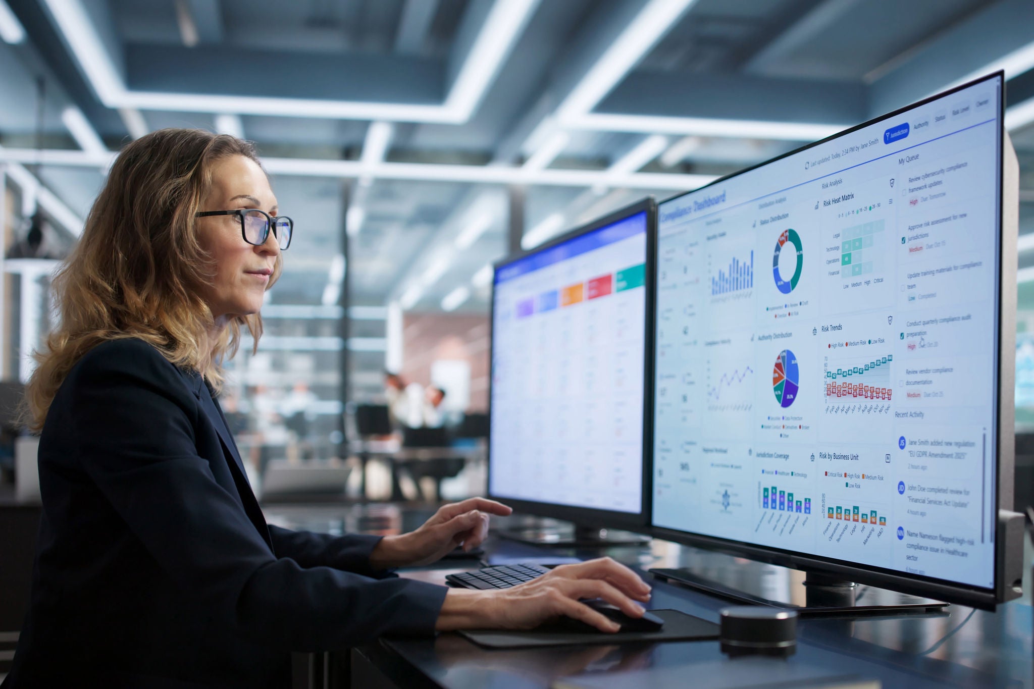Person arbeitet an großen Bildschirmen mit Analyse-Dashboard im Büro.