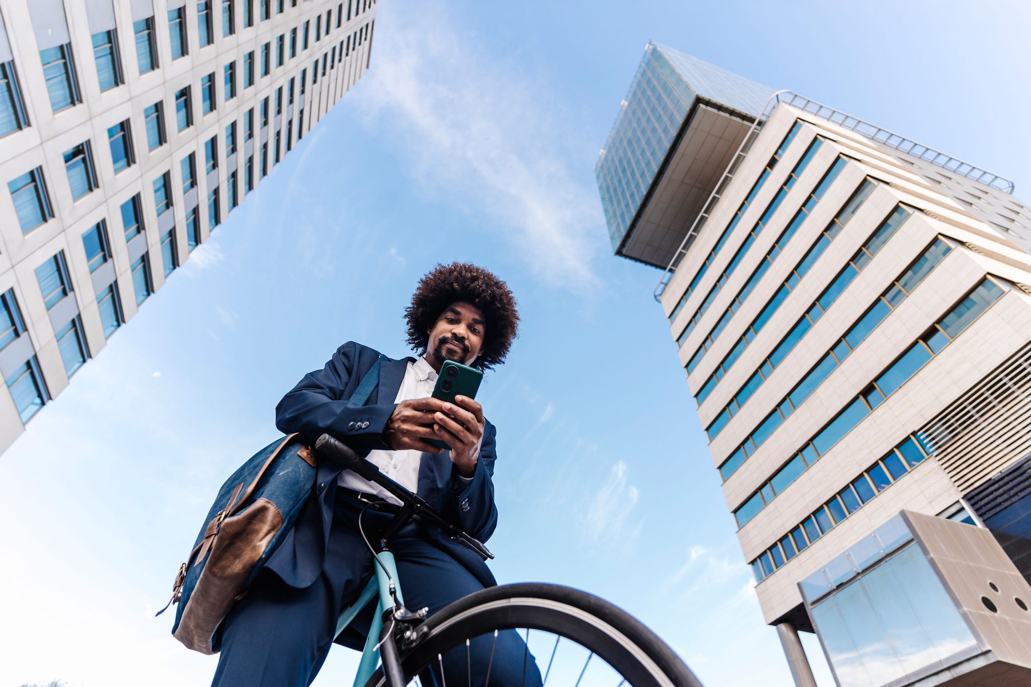 High angle rear view of male programmer coding on laptop while sitting at desk in startup office