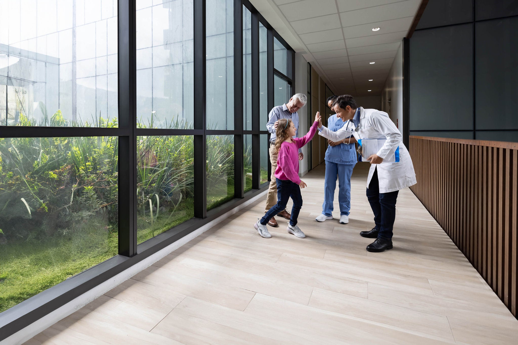 Doctor giving a high-five to a girl at the hospital