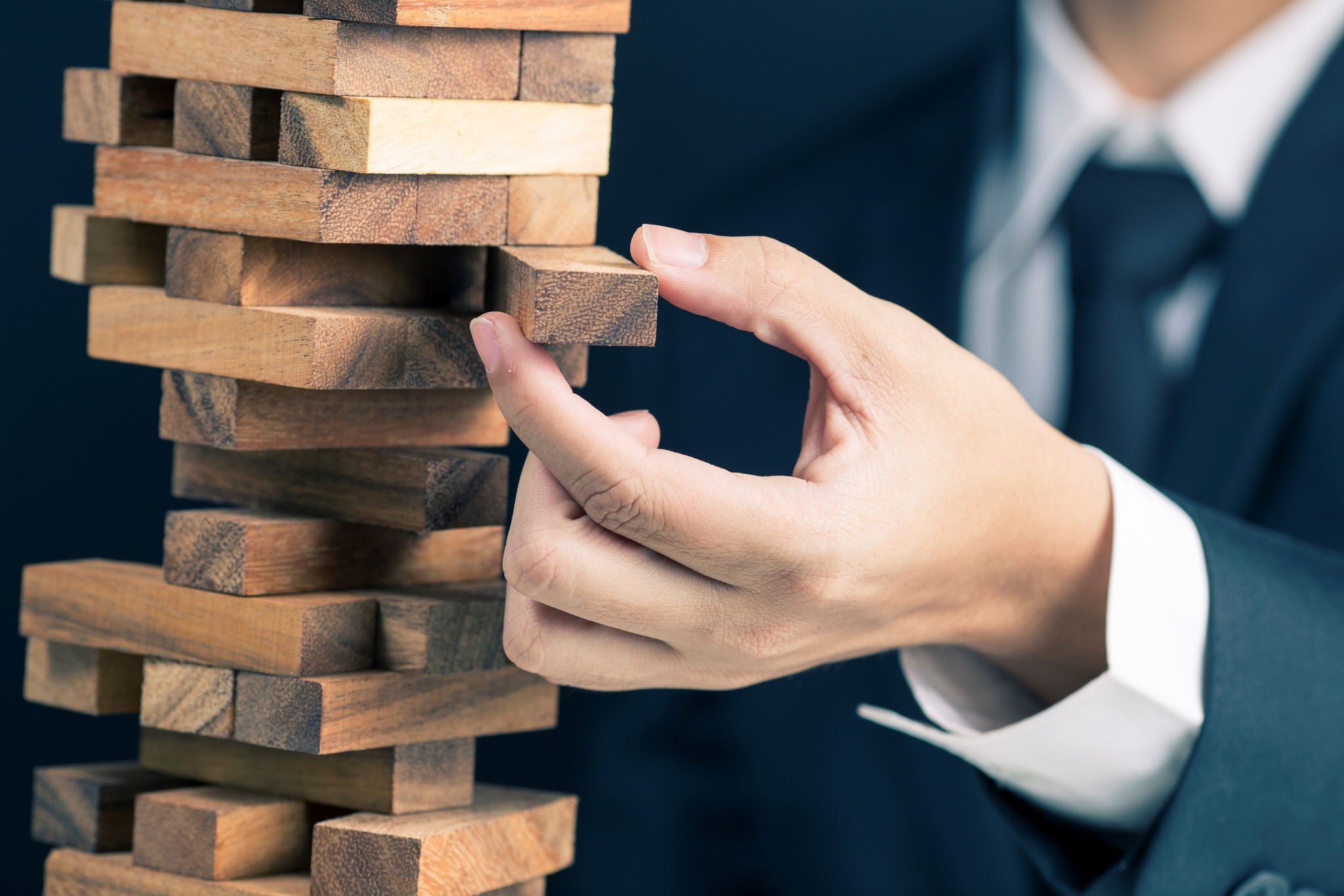 man in business suit playing jenga