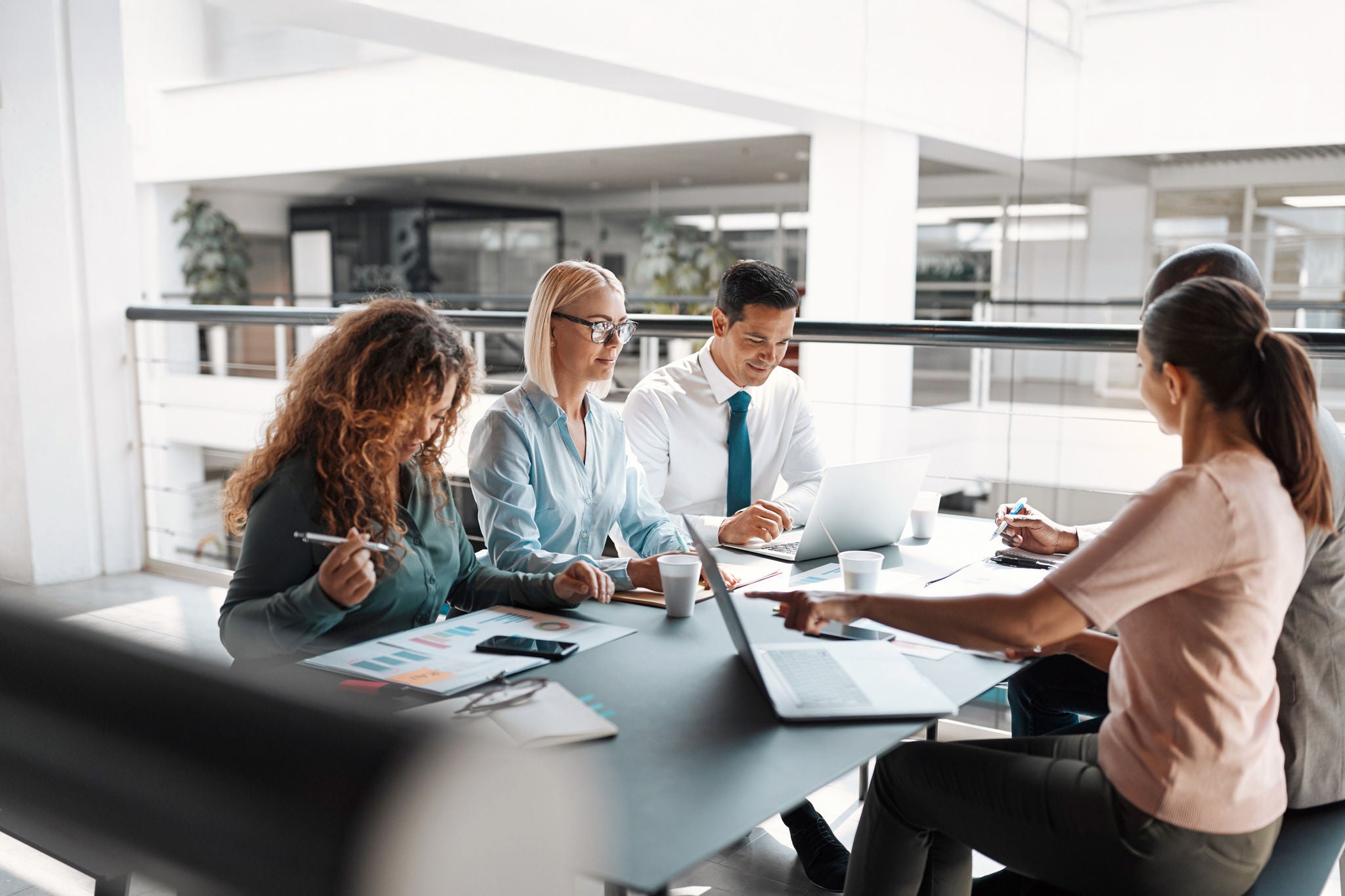 Diverse group of businesspeople sitting at a table in an office complex having a meeting