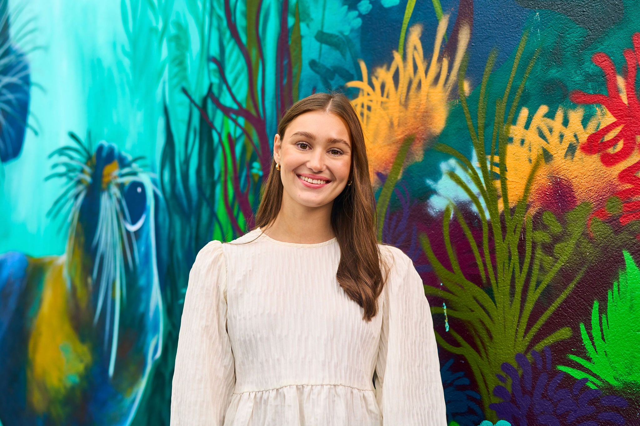 Hannah standing next to a colourful wall