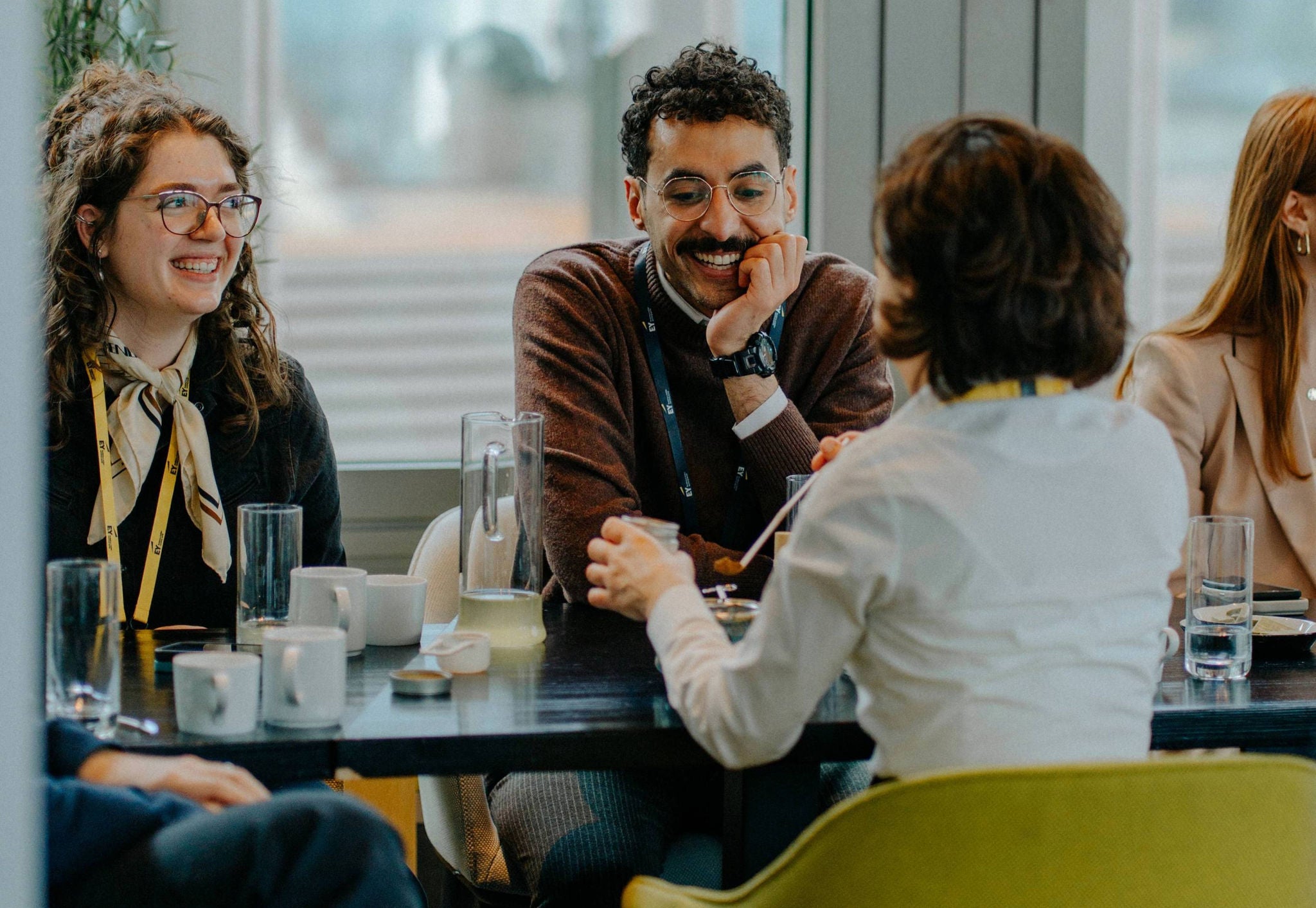 Mehrere Personen sitzen lächelnd an einem Tisch