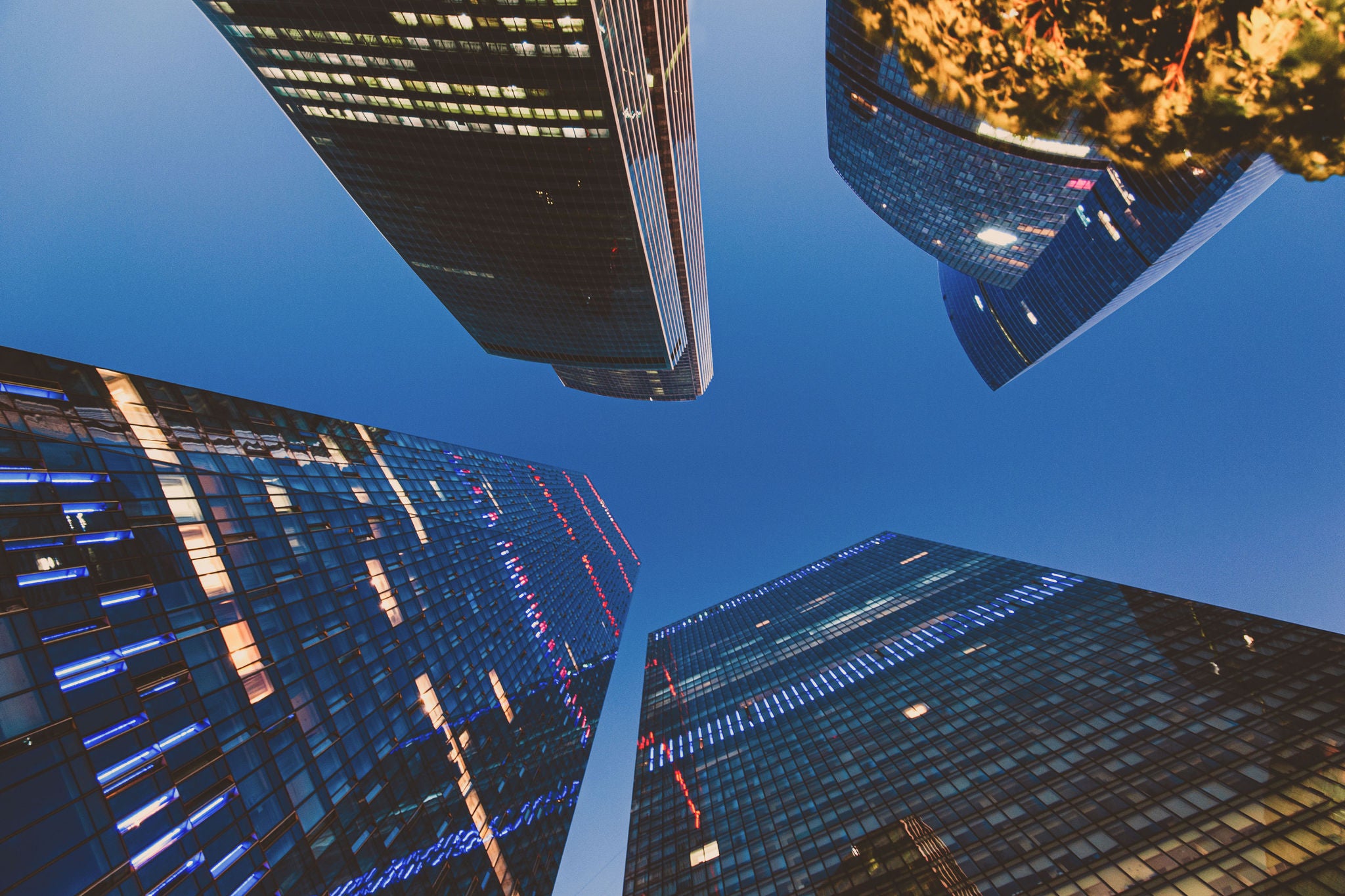 Looking up at skyscrapers against dark blue sky at night in moscow