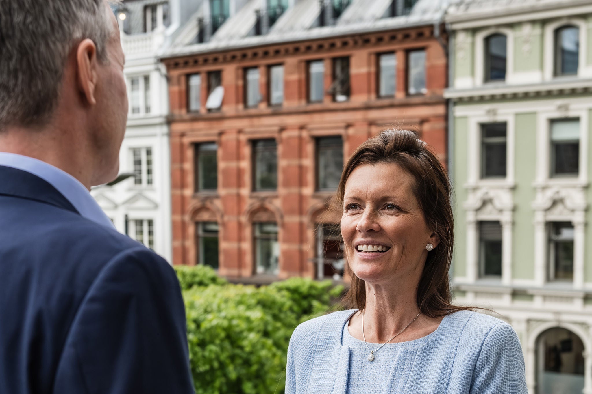 Professionals in conversation outdoors in a business district