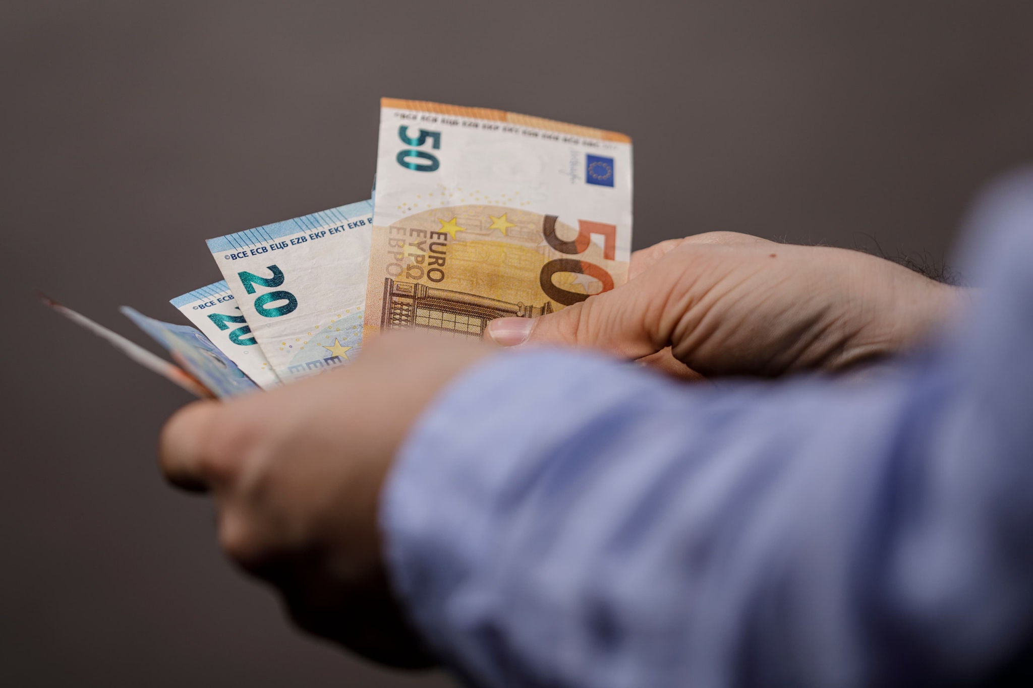 Mann zählt Geldscheine in den Händen