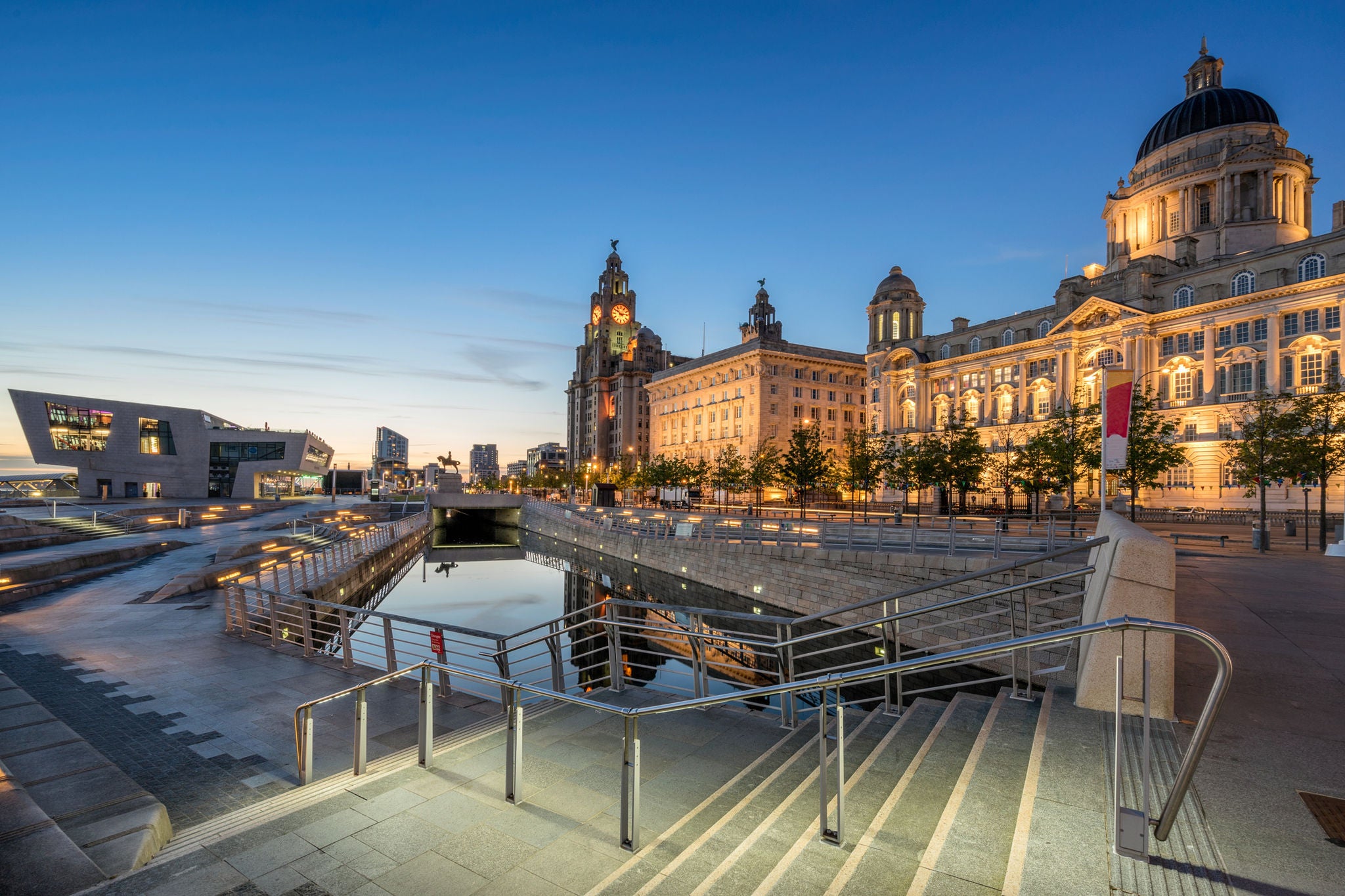 Illuminated waterfront buildings and canal at dusk in Liverpool