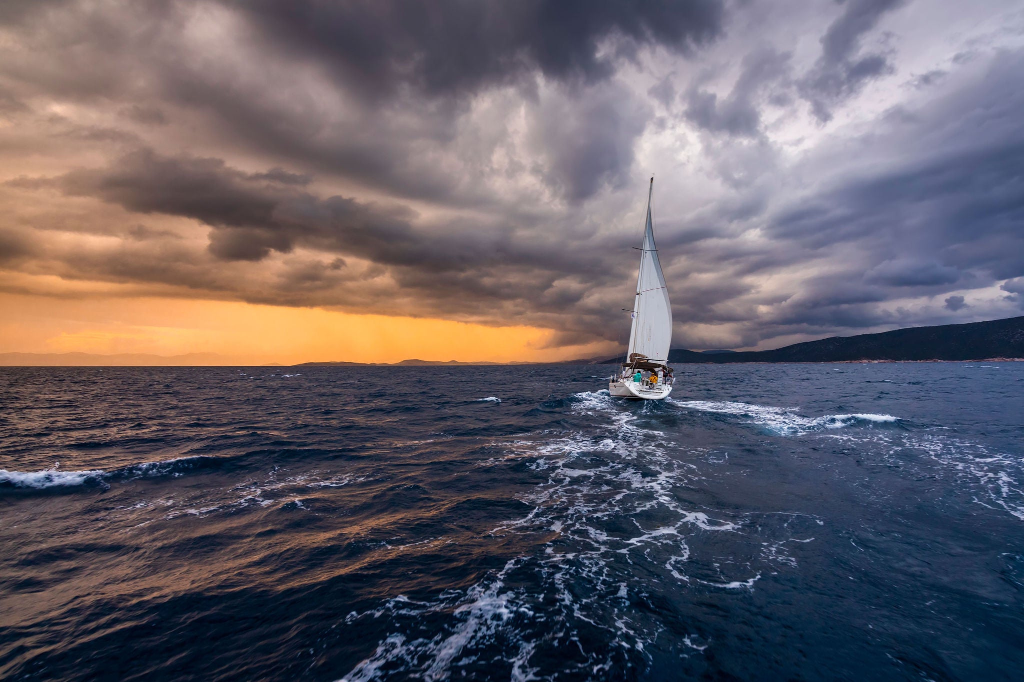 yatch with white sails on a background of storm cloud at sea