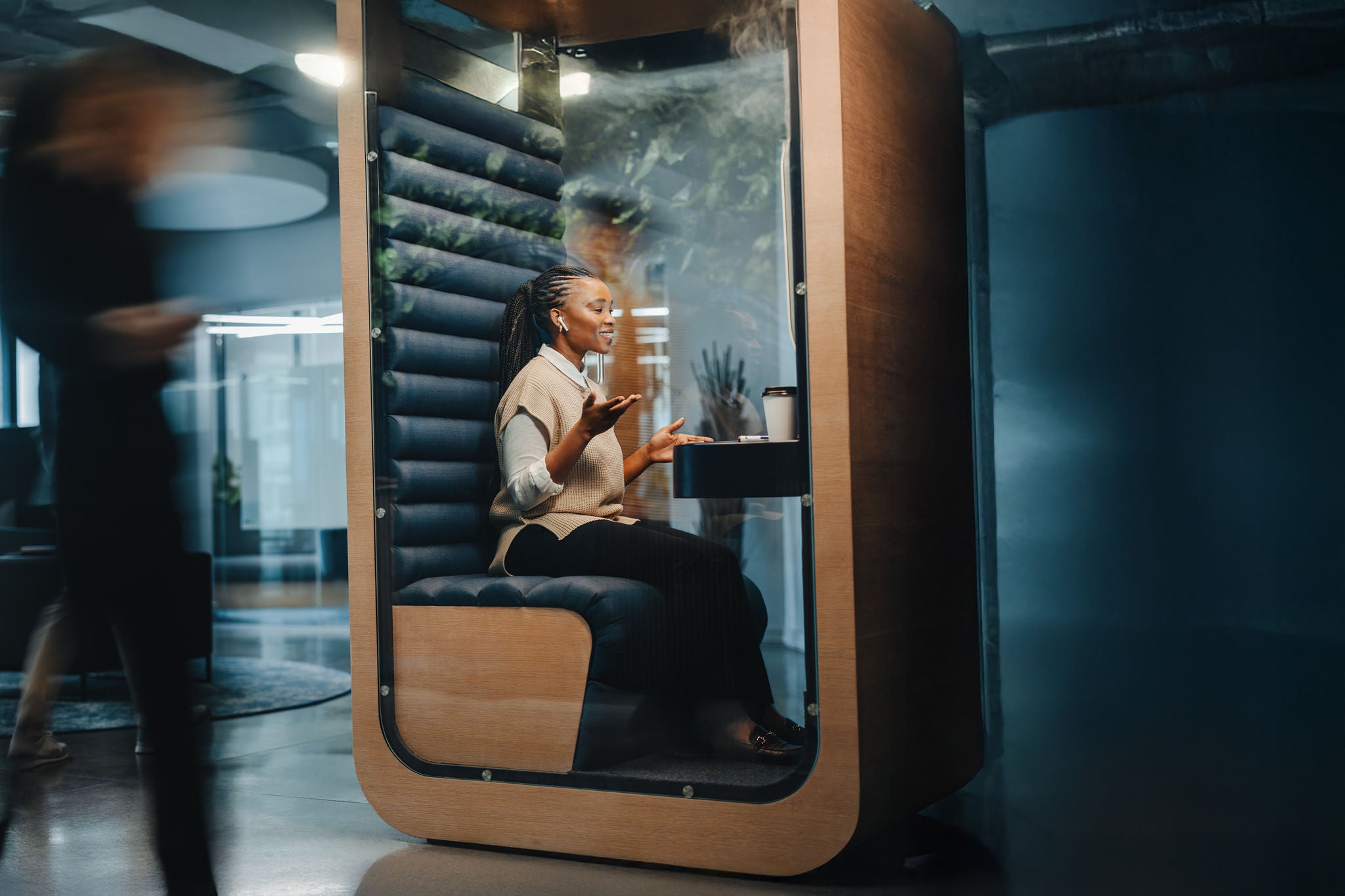 Successful young businesswoman smiling while working in a privacy booth