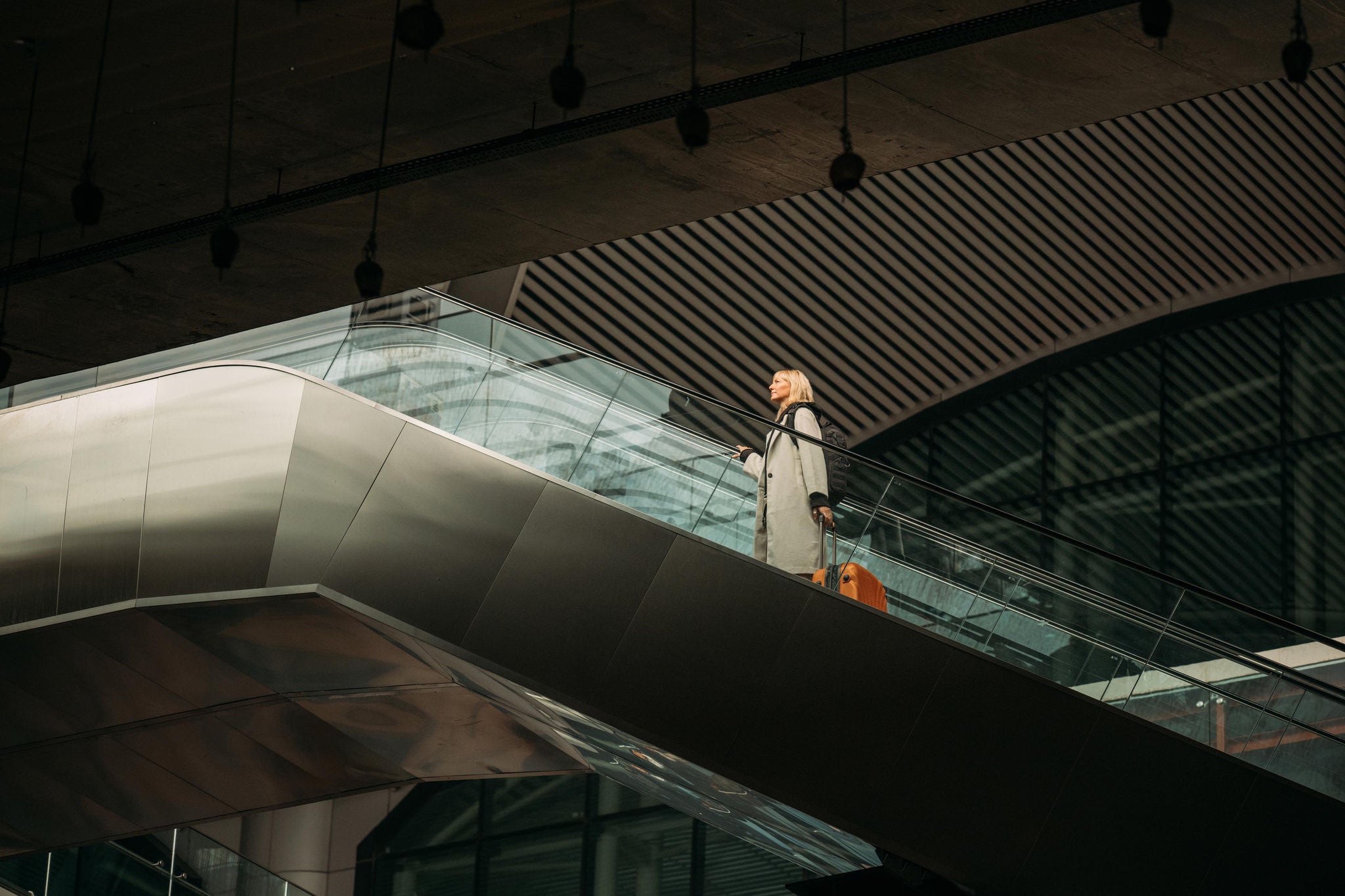 Woman on escalator in modern airport terminal