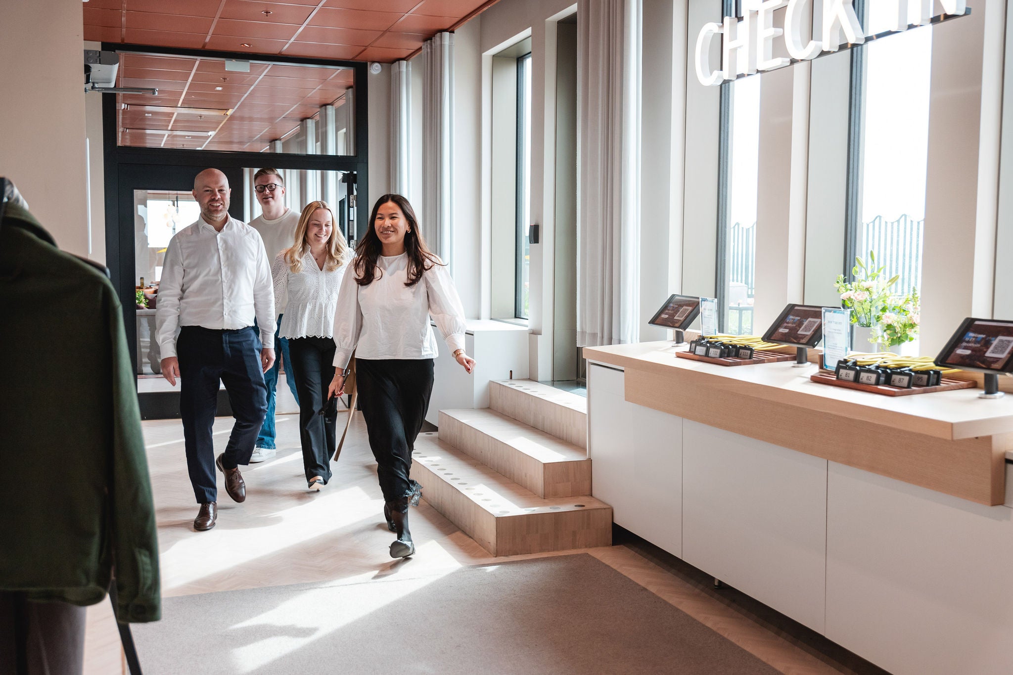 Yrkesverksamma som går tillsammans genom en modern kontorsreception.
