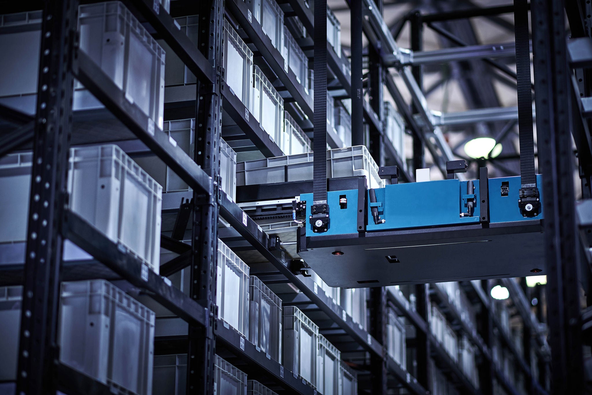 Side view of robot carrying merchandise at modern dark distribution warehouse and unmanned factory.