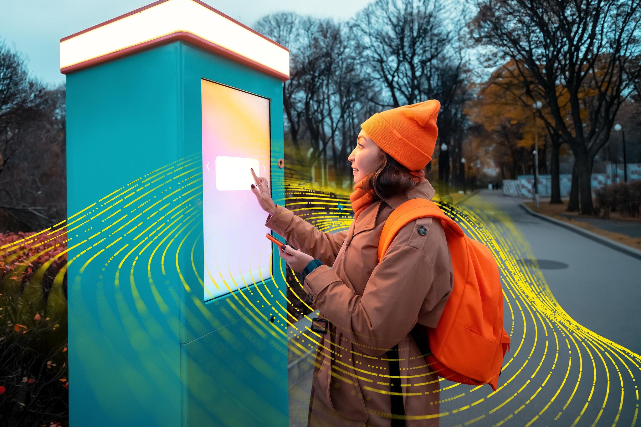 Individual interacting with a smart kiosk in a park setting