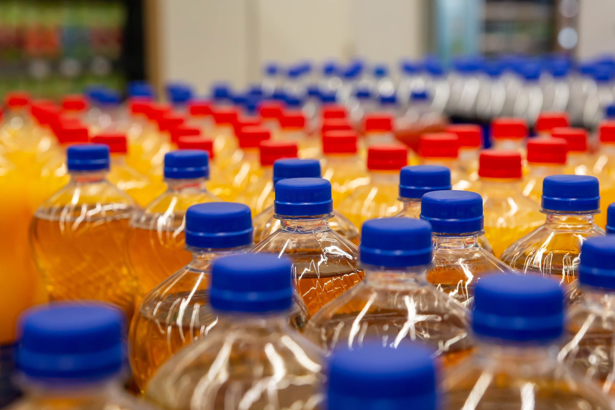 Assorted plastic beverage bottles with blue caps