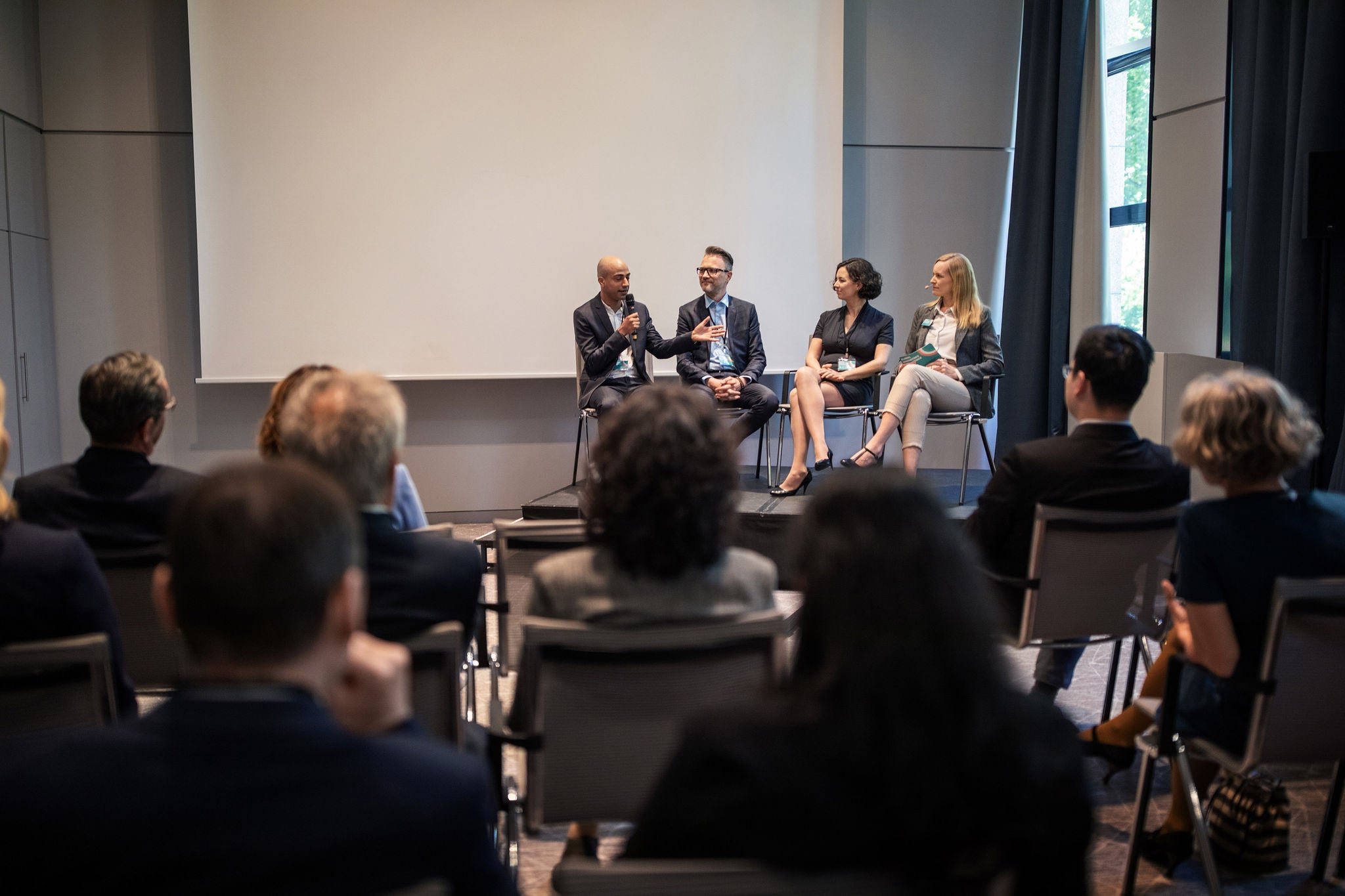 En lille gruppe af forretningsfolk diskuterer strategi ved en paneldebat under et seminar