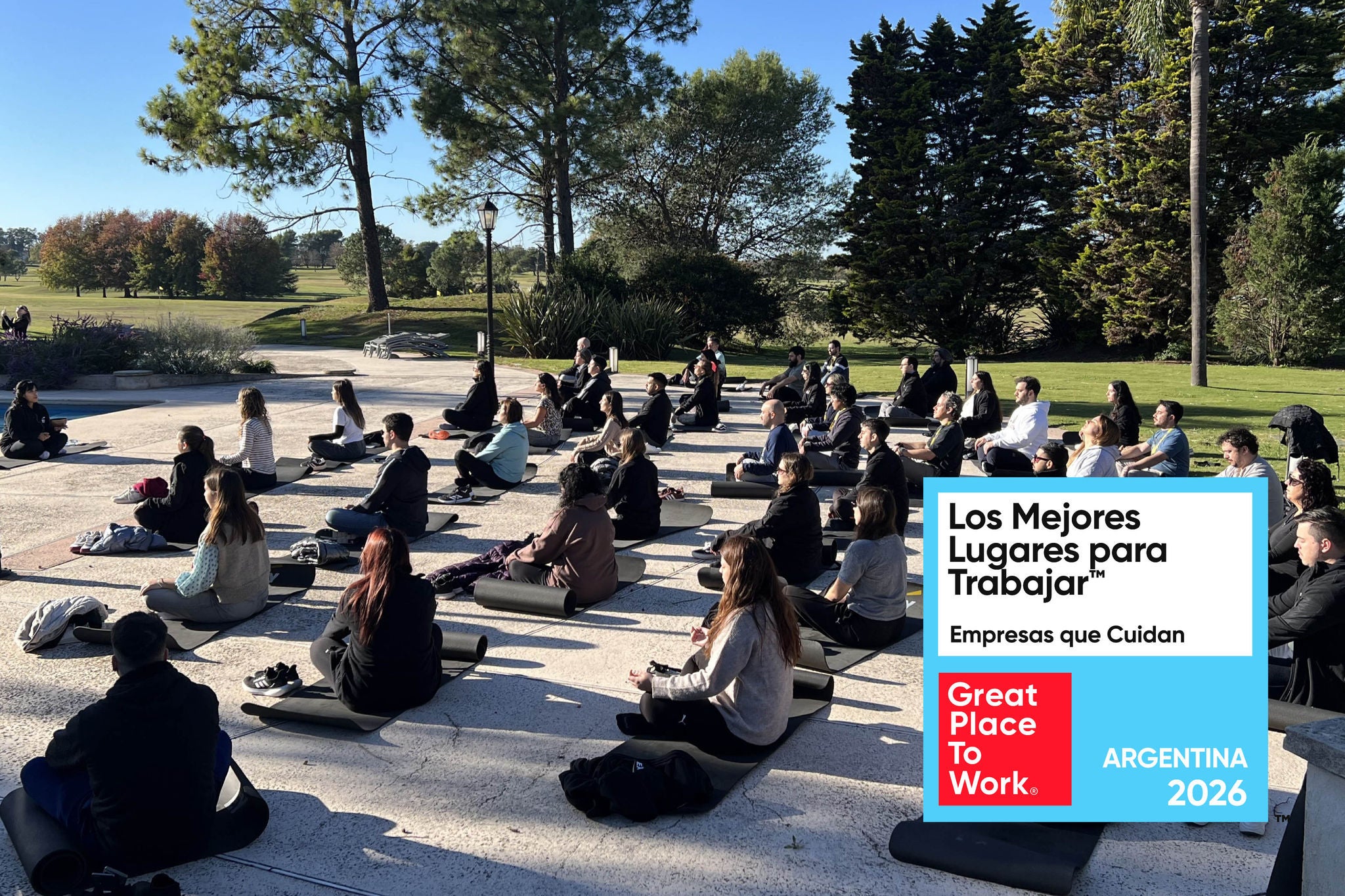 Personas meditando al aire libre en un parque con reconocimiento Great Place To Work® Argentina 2026.