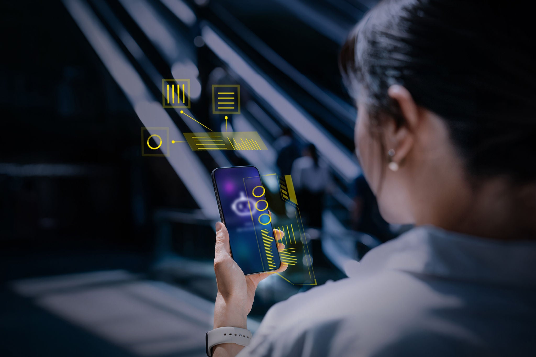 Young Asian businesswoman speaking to virtual assistant, chatting AI chatbot app on smartphone in front of escalator.