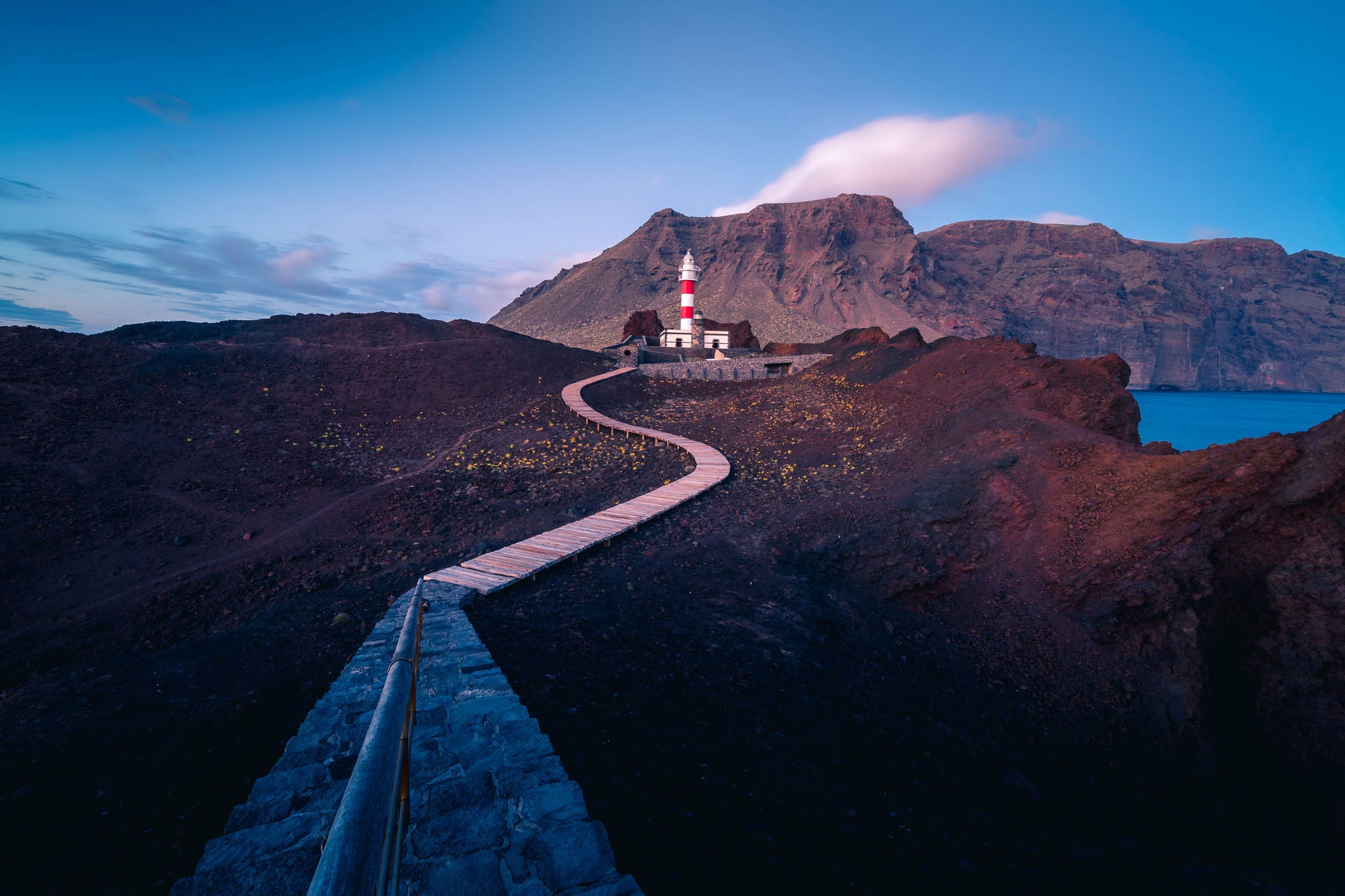 Pathway leading to a lighthouse at dusk.