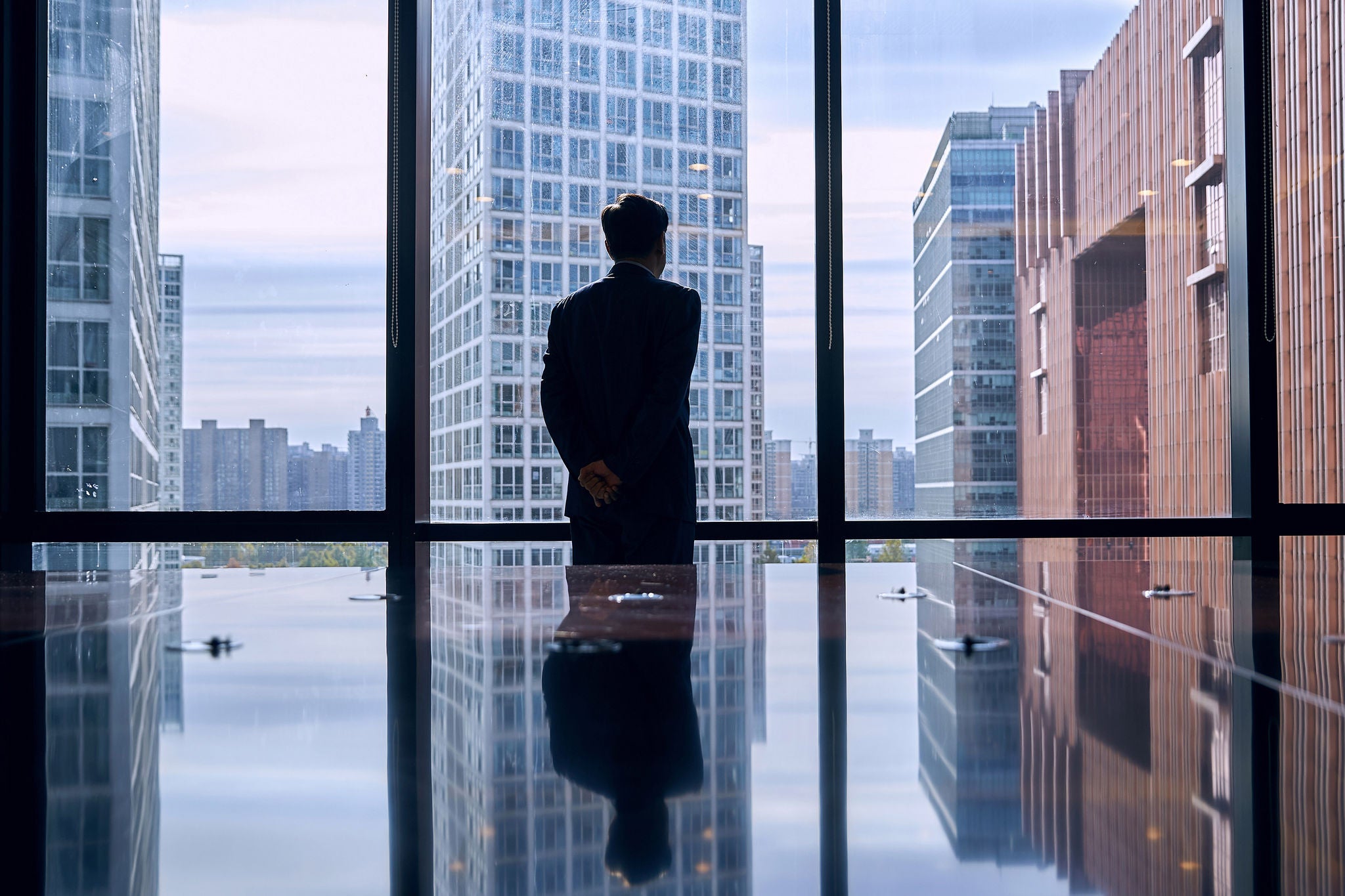 Businessmen in an office looking out the window at the city’s financial district