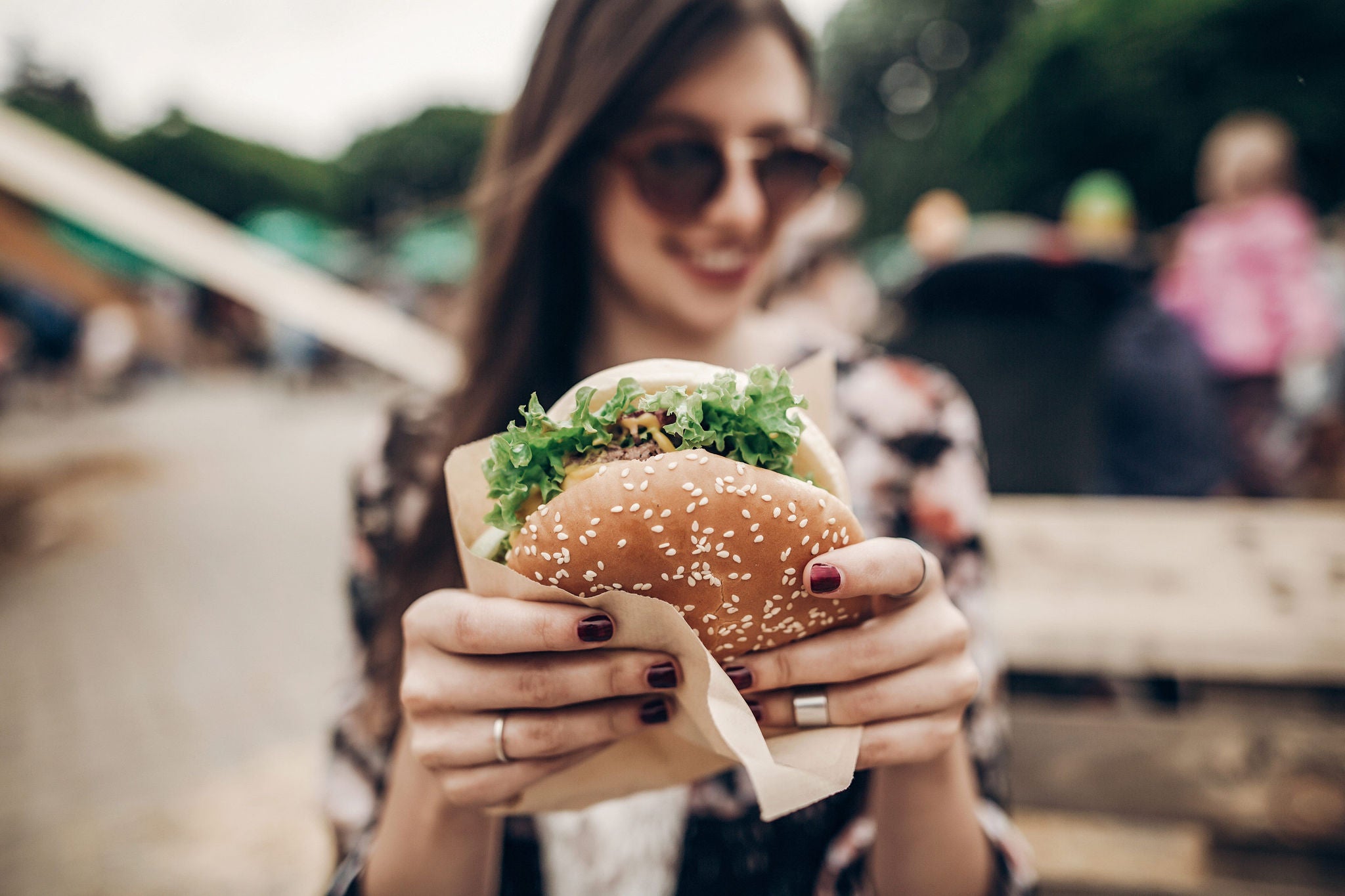 Girl holding hamburger close up